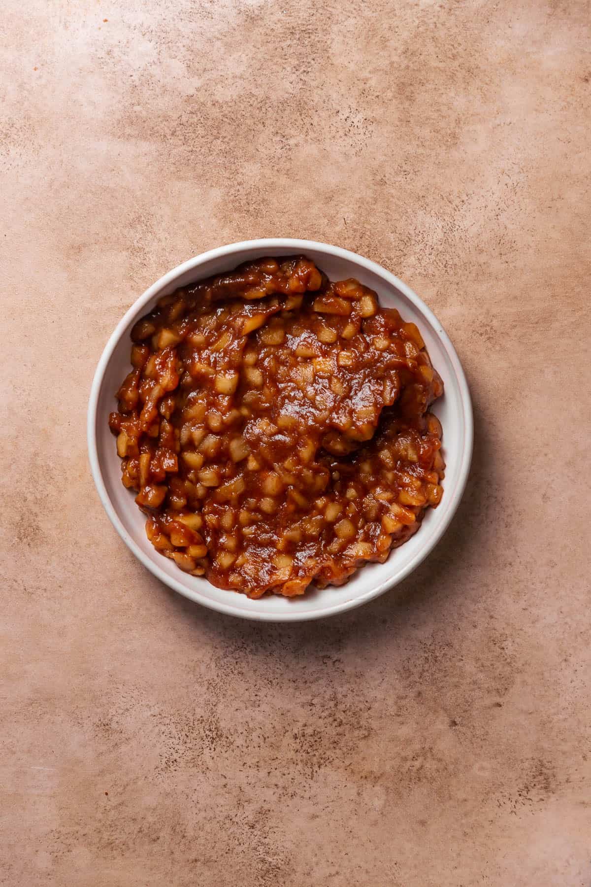 Spiced apple pie filling in a white dish.