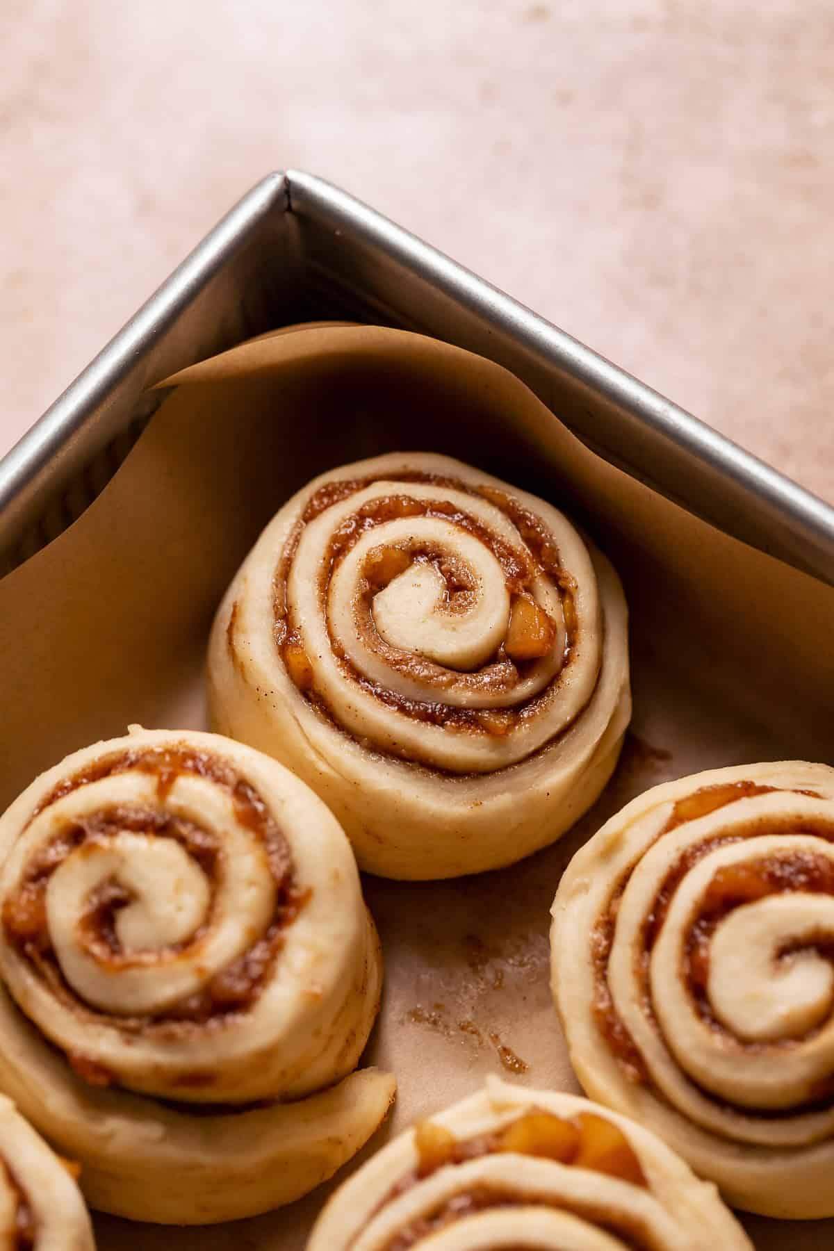 Apple cinnamon rolls in a baking pan before baking.
