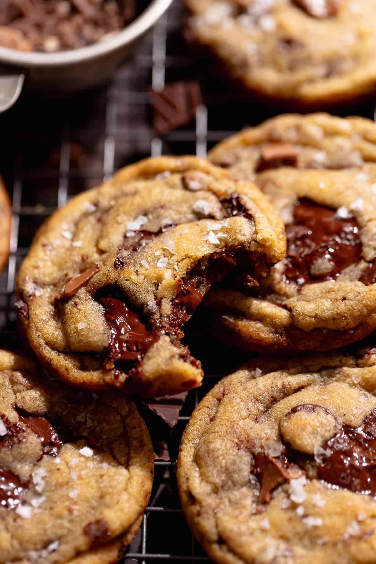 A chocolate chip cookie with a bite taken out of it resting on another cookie.