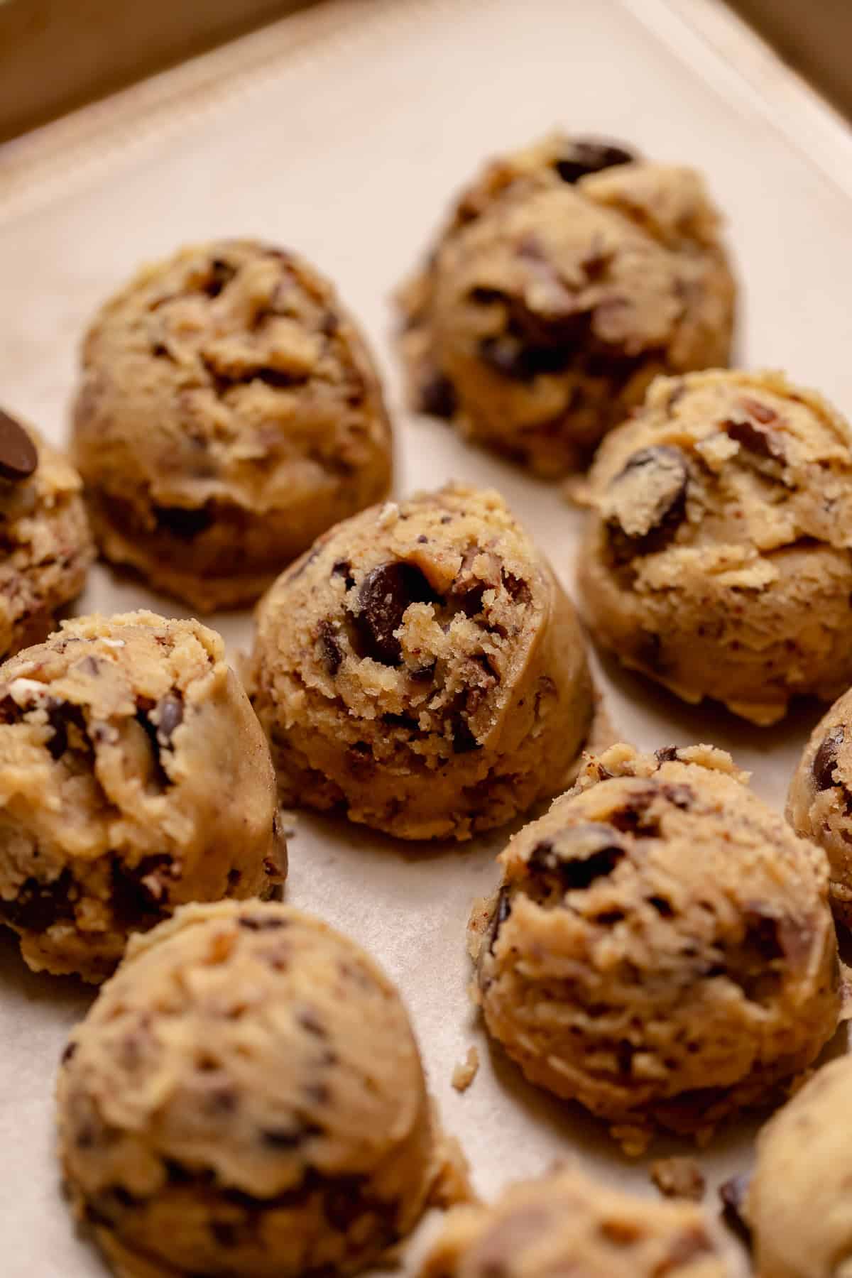 Brown butter chocolate chip cookie dough balls on a baking tray.
