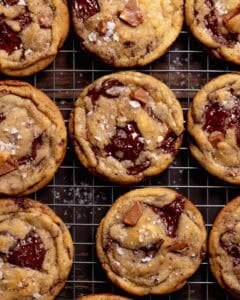 Brown butter chocolate cookies on a wire rack sprinkled with flaky sea salt.