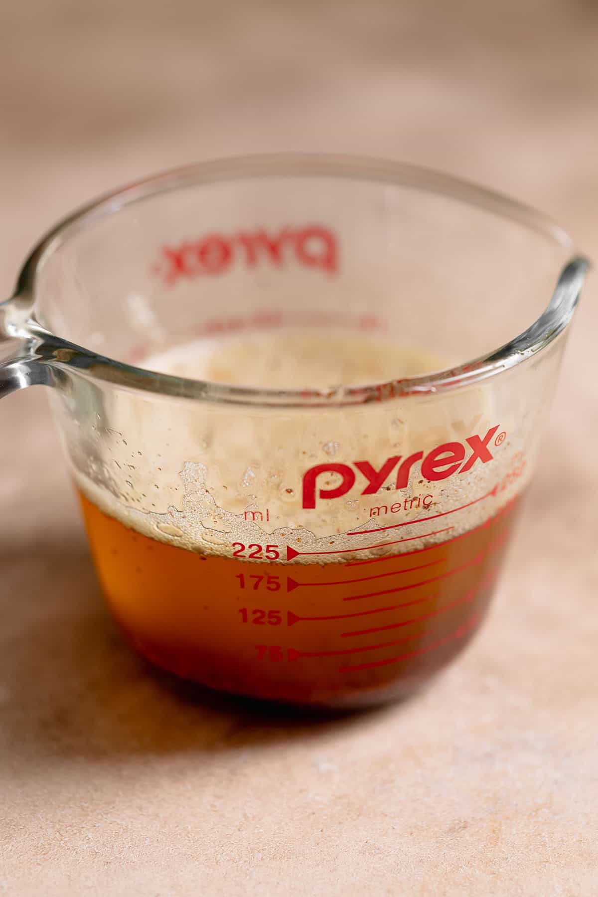 Browned butter in a glass measuring cup.