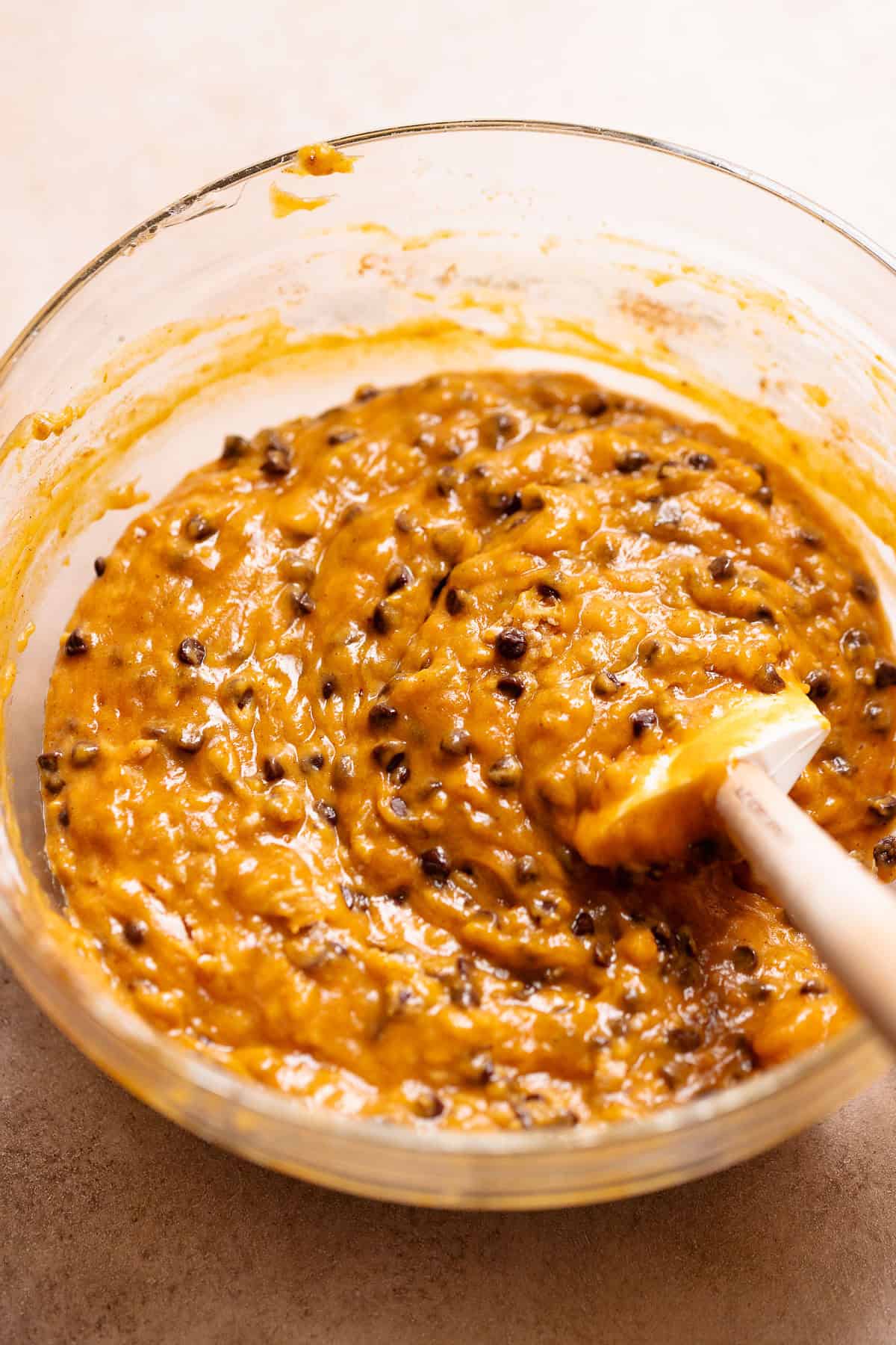 A bowl of the pumpkin bread batter with mini chocolate chips folded in.