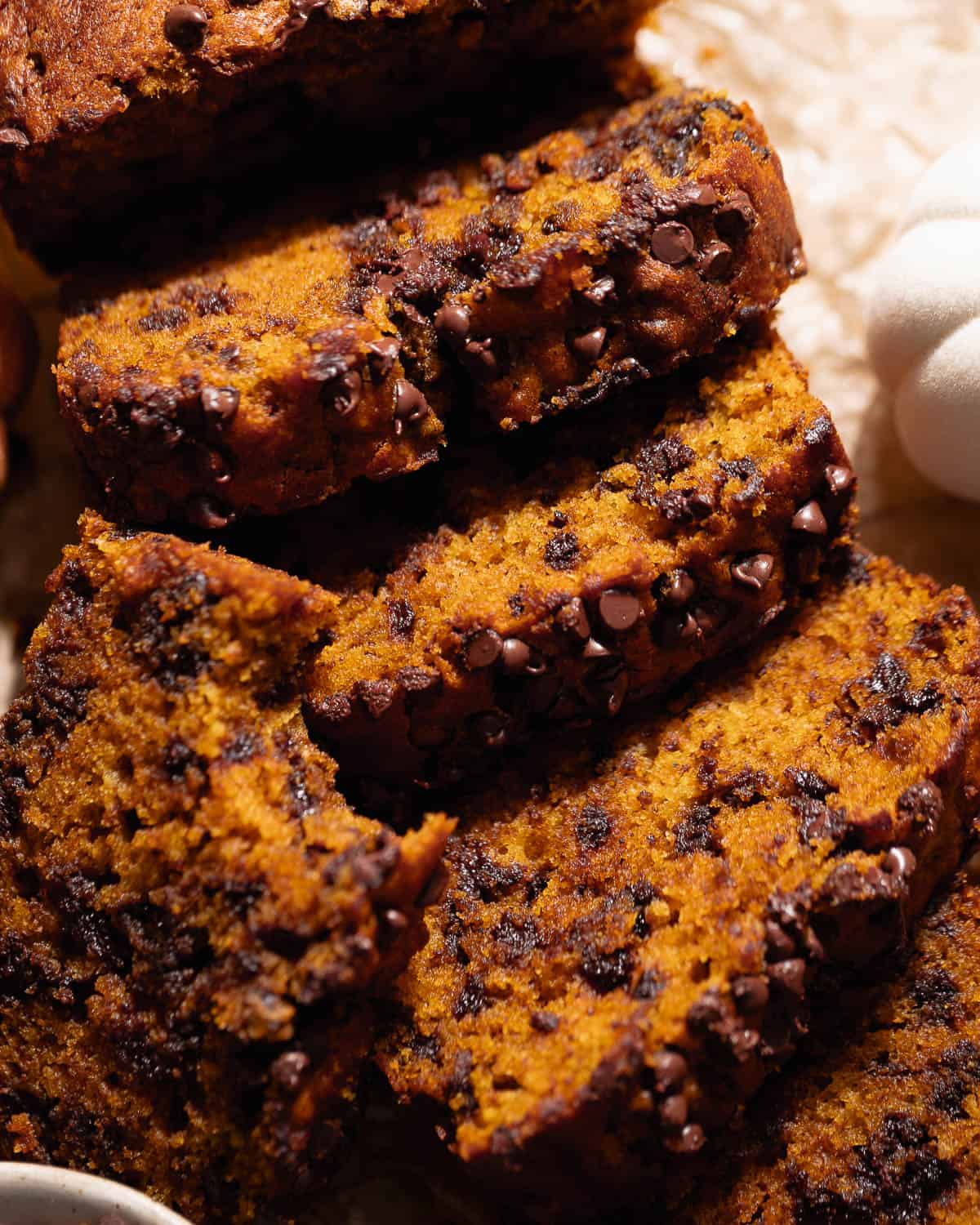 Slices of chocolate chip pumpkin bread laying on top of each other.