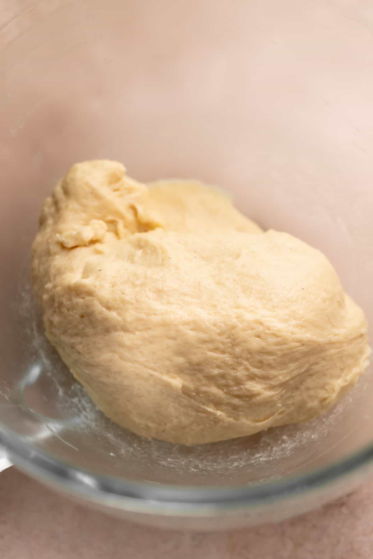 Cinnamon roll dough resting in a mixer bowl before being made into monkey bread.