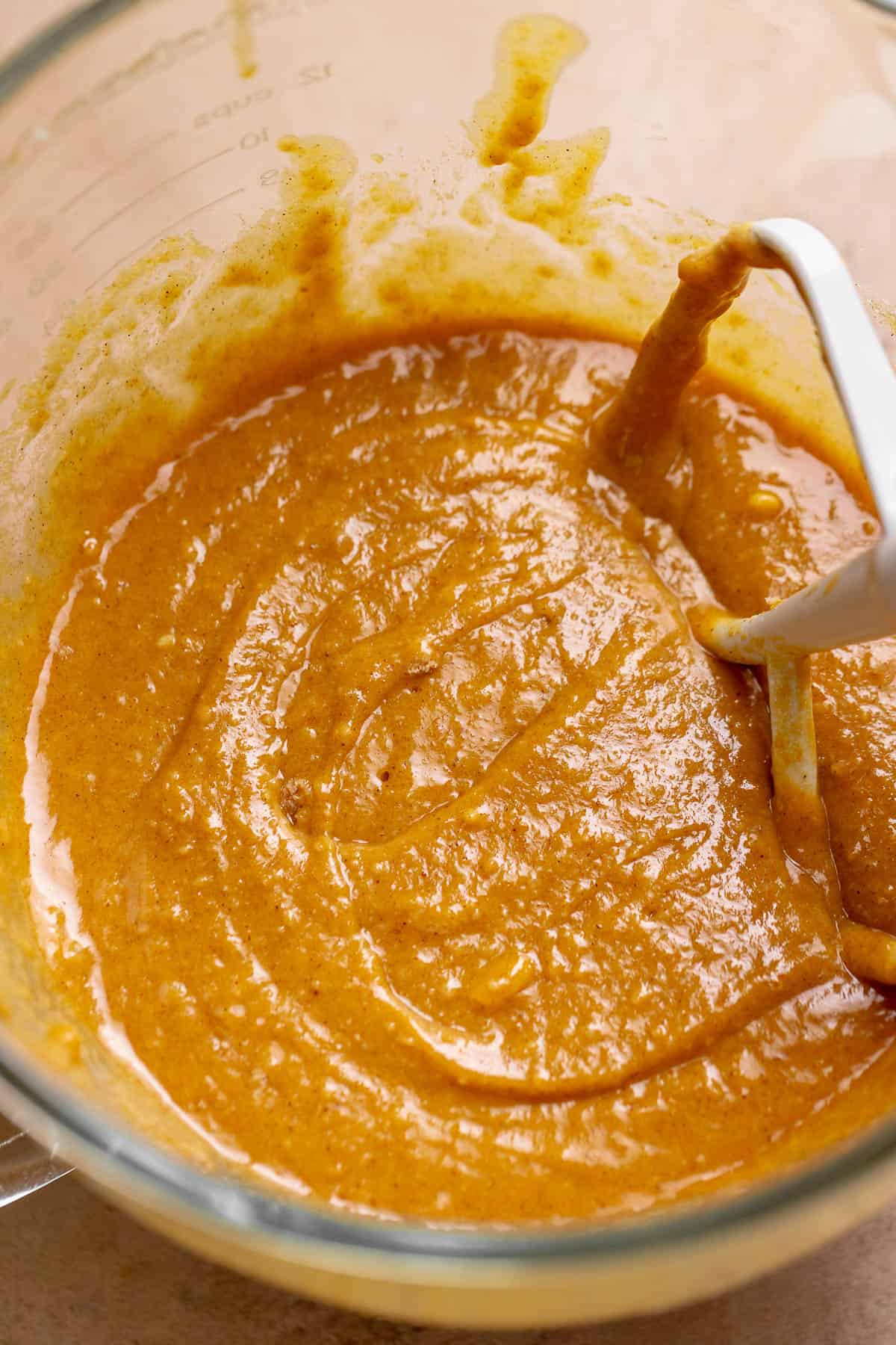 Pumpkin cupcake batter in a glass mixing bowl.