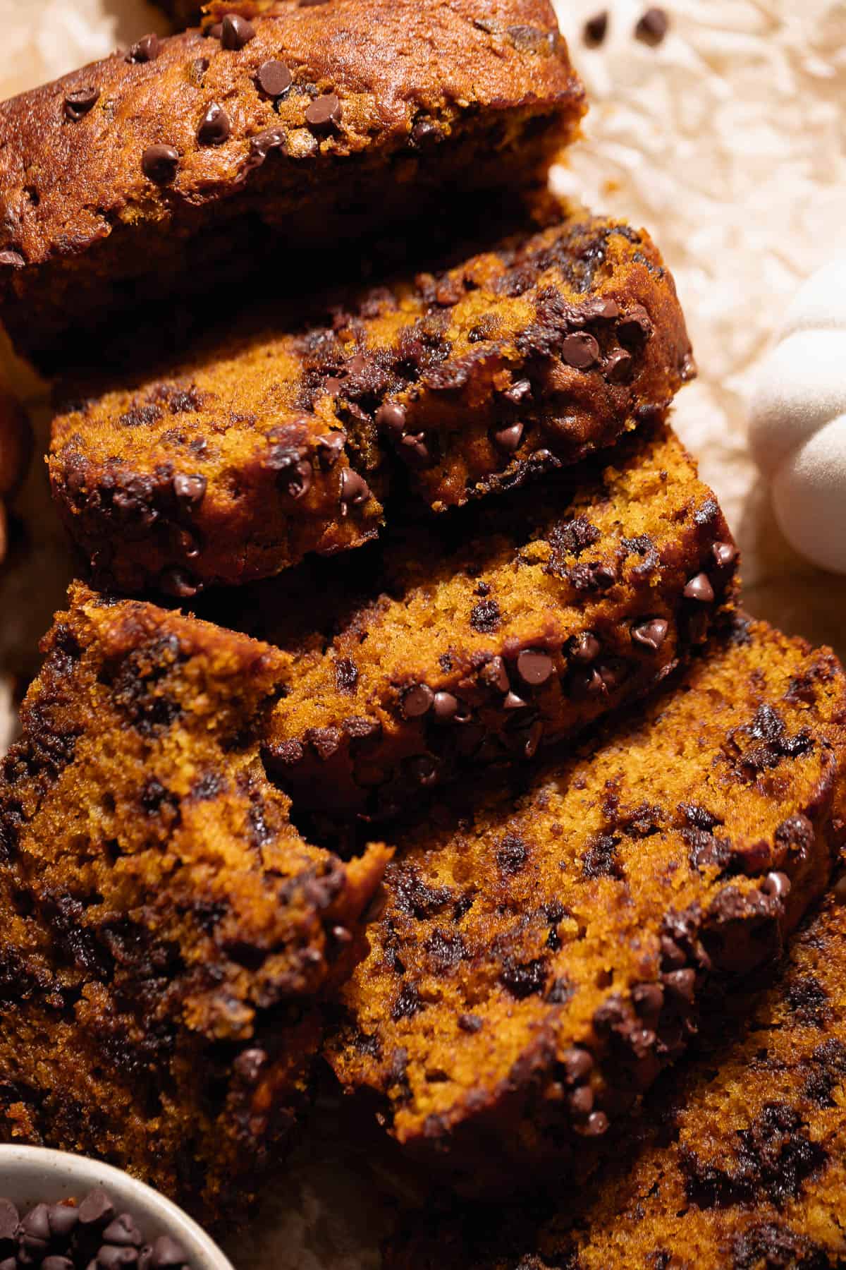 Slices of pumpkin cake with chocolate chips laying on top of each other.