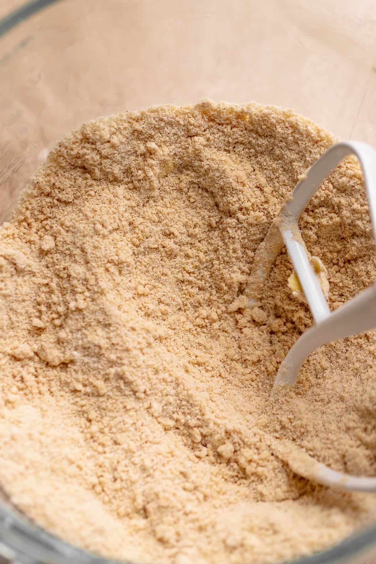 A mixing bowl with the butter mixed into the dry ingredients until it looks crumbly.