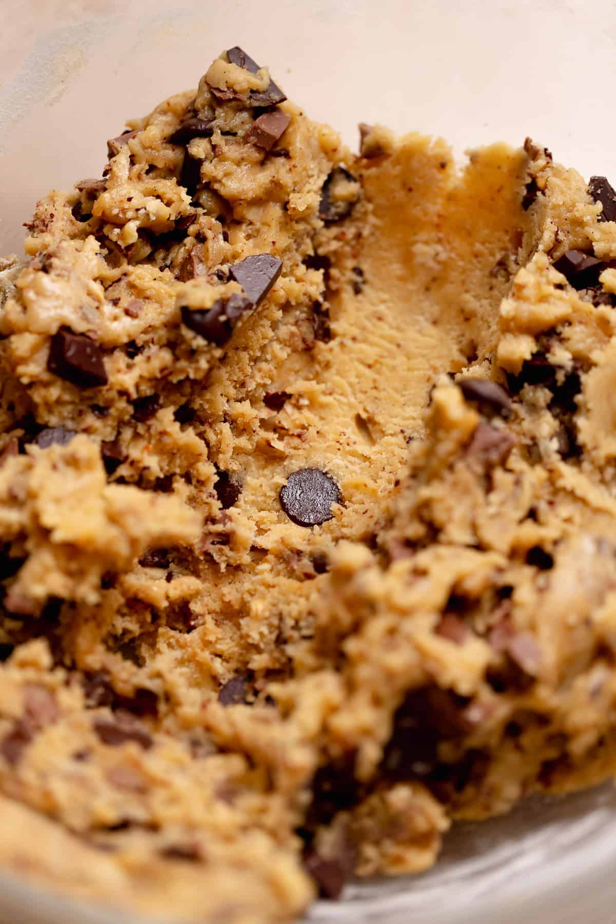 A close up of a line of scooped cookie dough in the glass bowl.