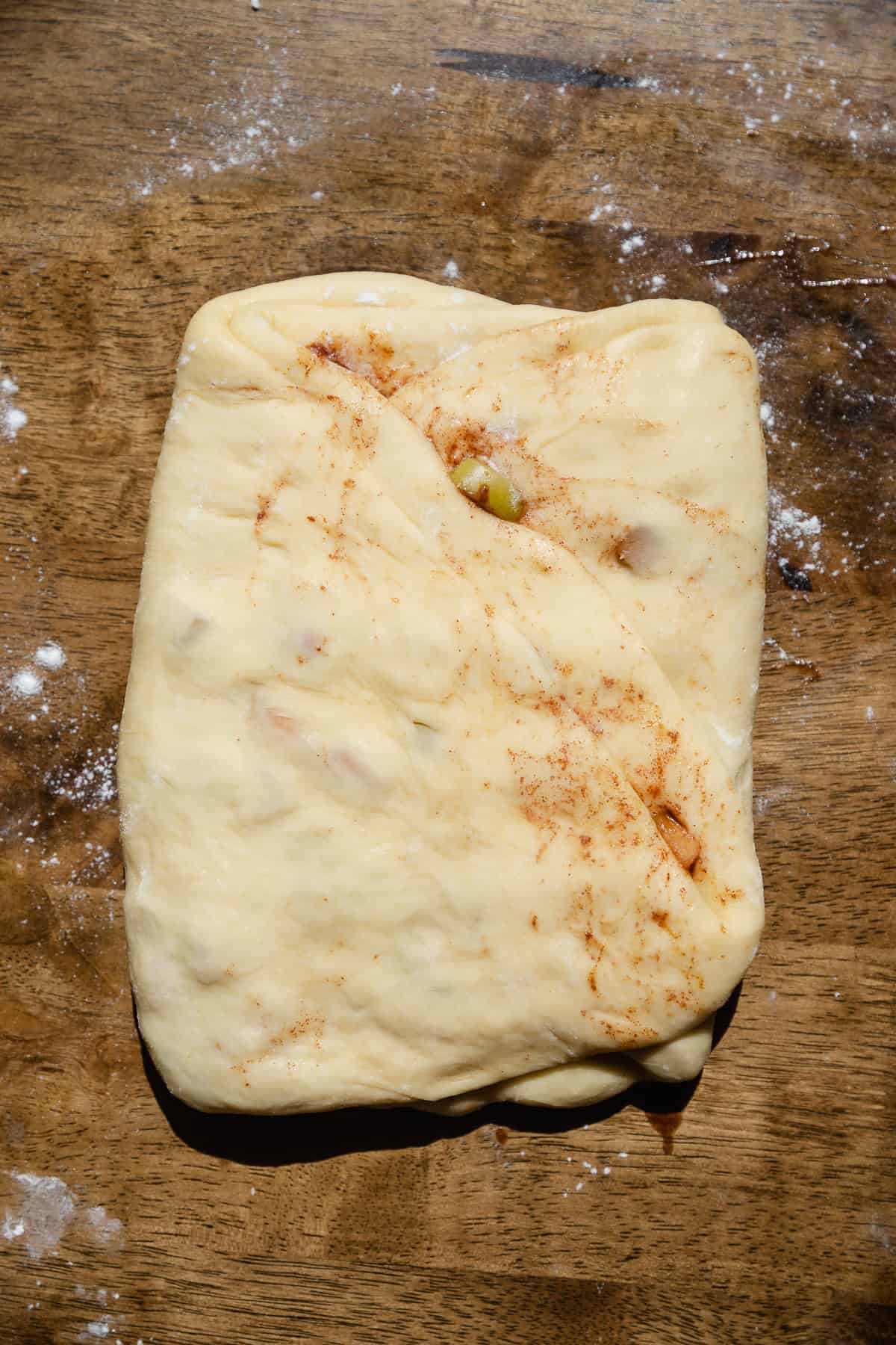 Fritter dough folded up to seal in the apple filling.