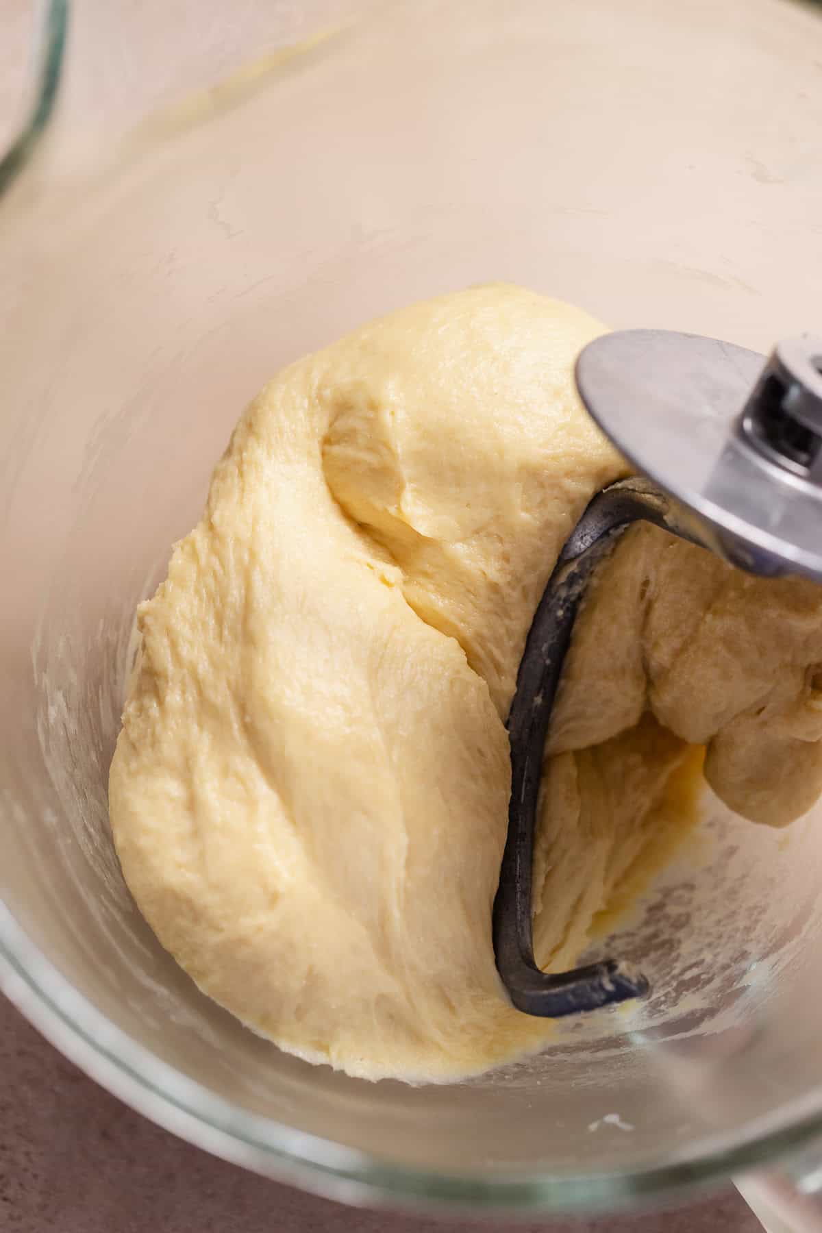 Soft kneaded fritter dough in a glass mixing bowl.