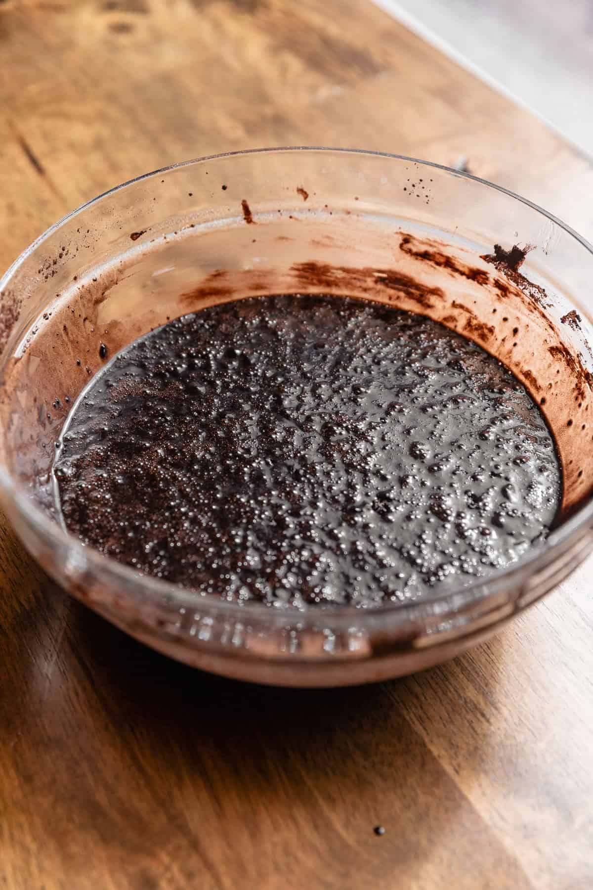 A glass bowl full of the black velvet cake batter.