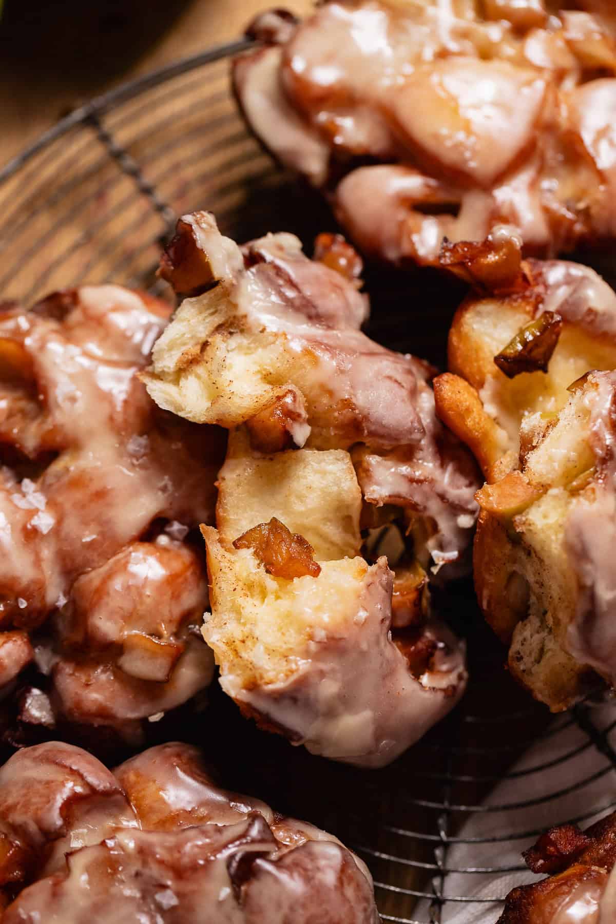 A fritter broken in half to show the soft centers and apples.