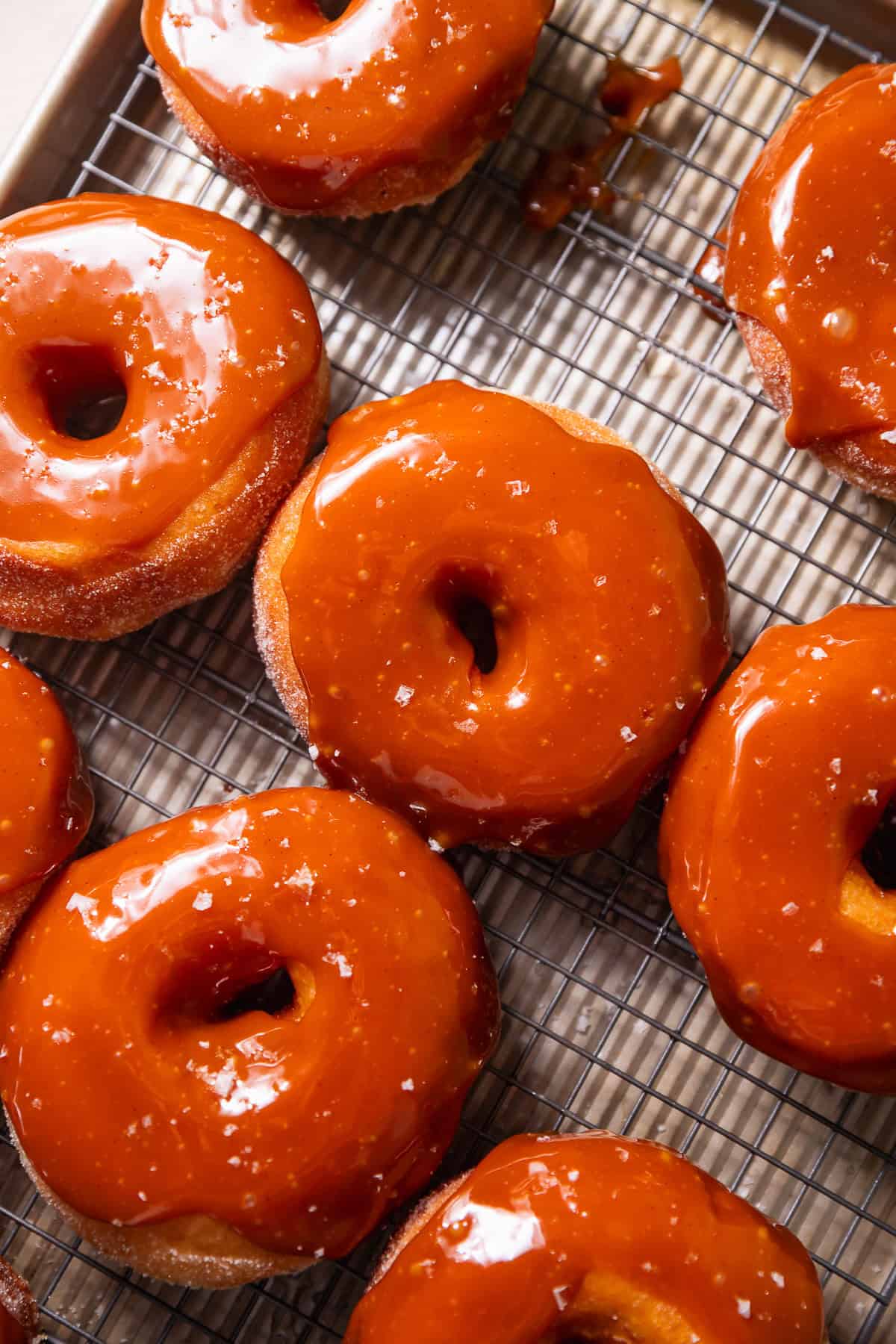 A wire rack with salted caramel donuts on top.