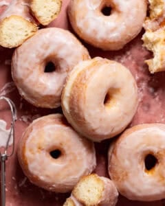Sugar glazed donuts on pink parchment paper.