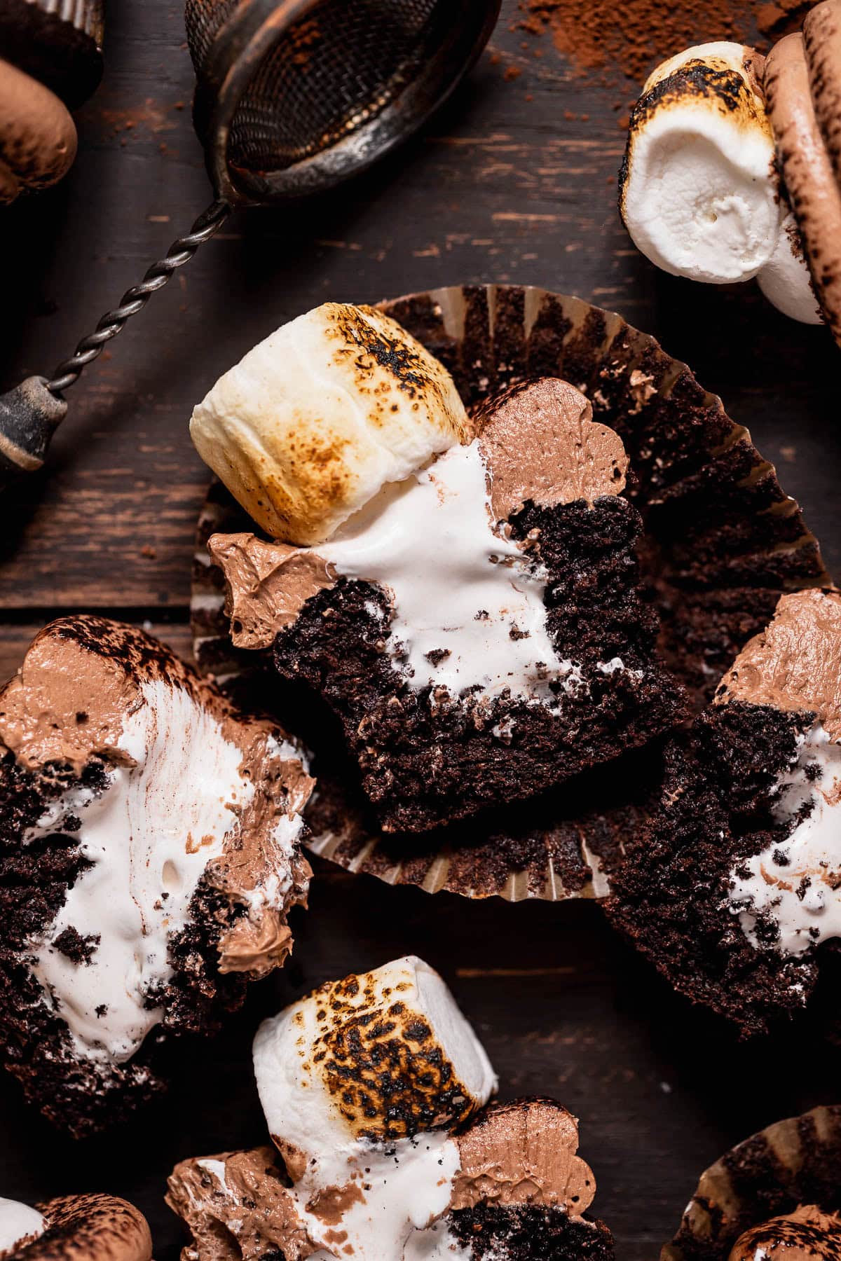 Hot cocoa cupcakes with marshmallow filling cut in half to show the filling oozing out.