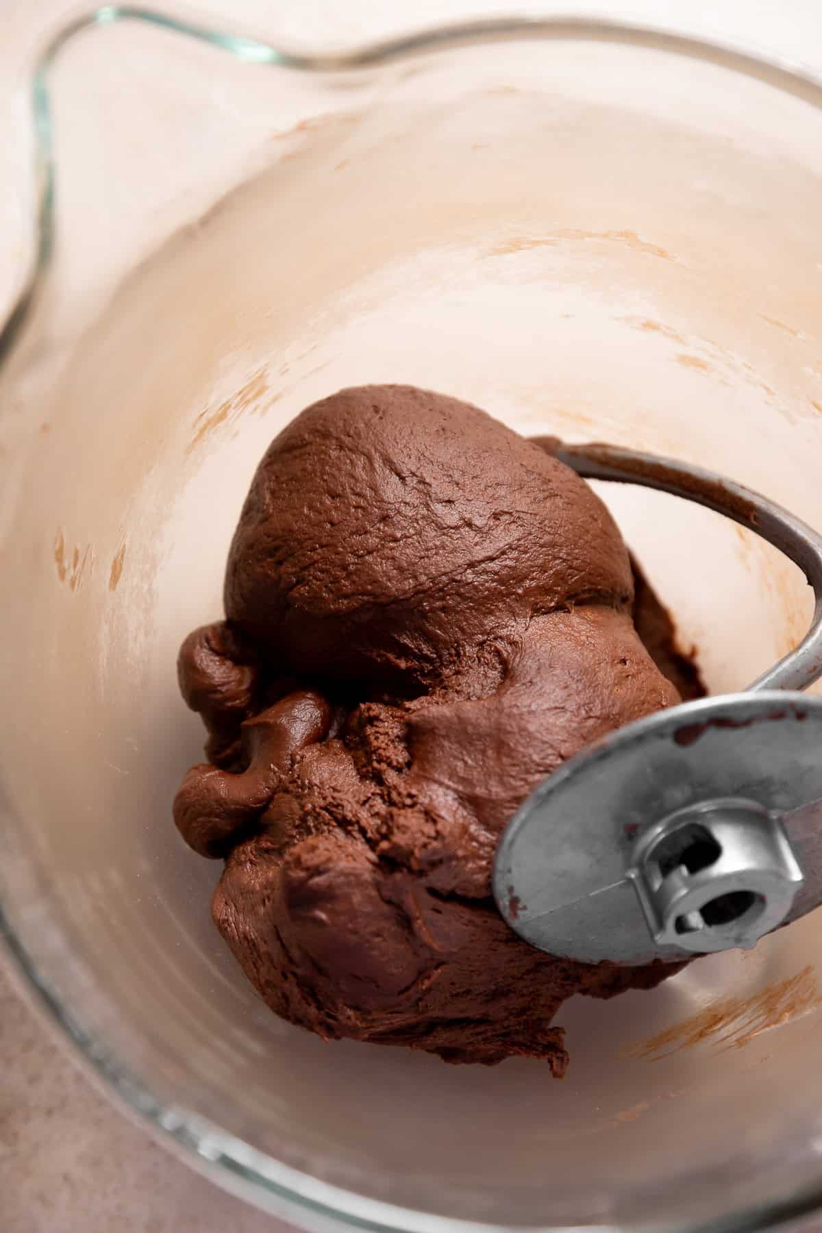 Kneaded chocolate yeast dough in a glass mixing bowl.