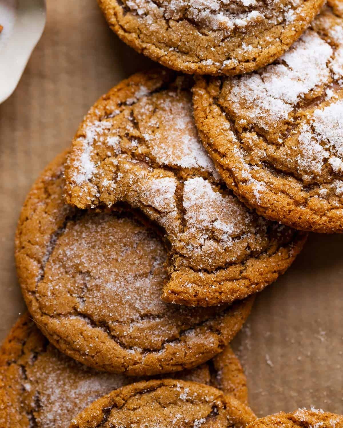 Ginger molasses cookies with crinkle tops on brown parchment paper.