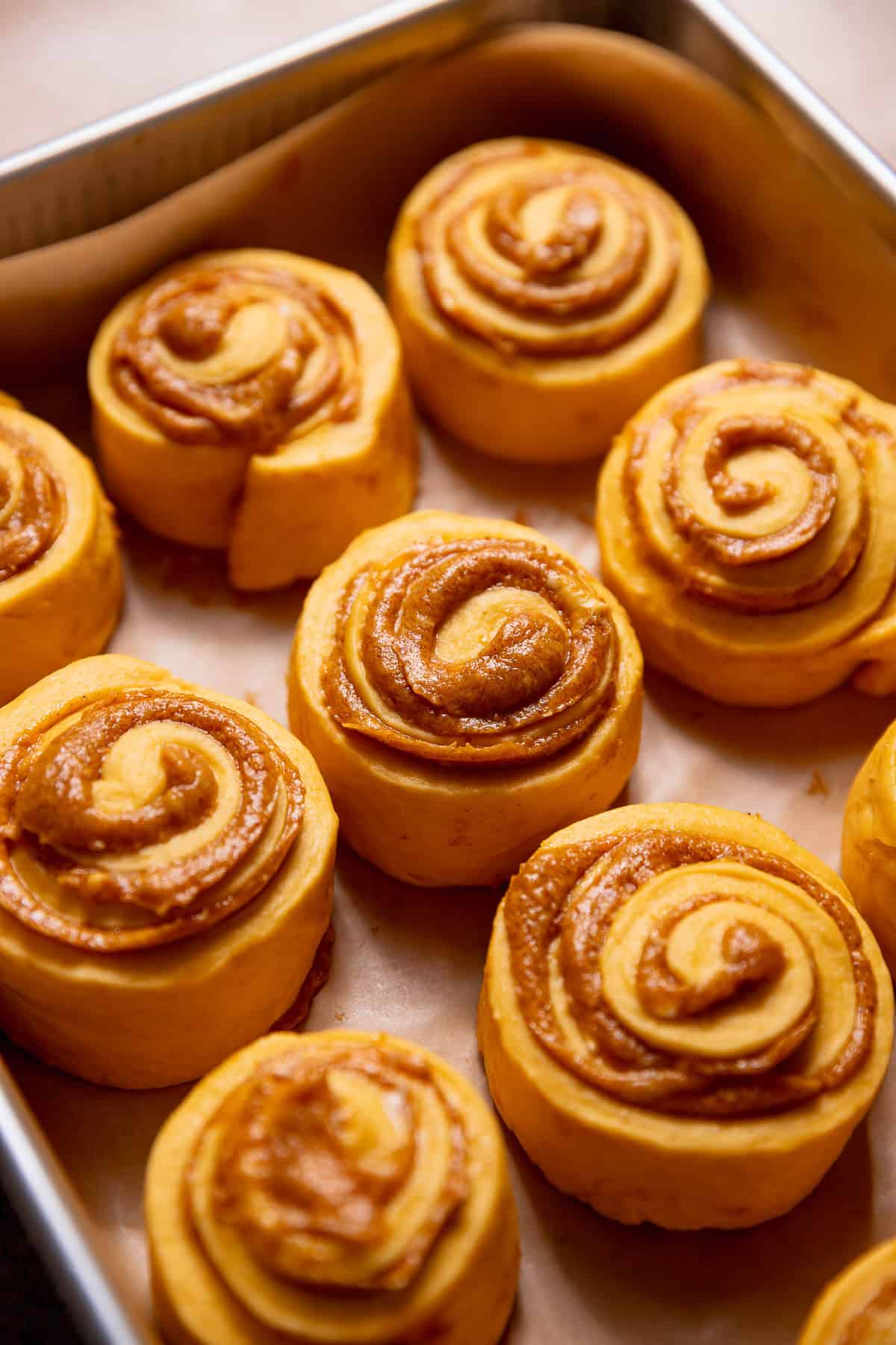 Pumpkin rolls with pumpkin pie filling in a baking pan.