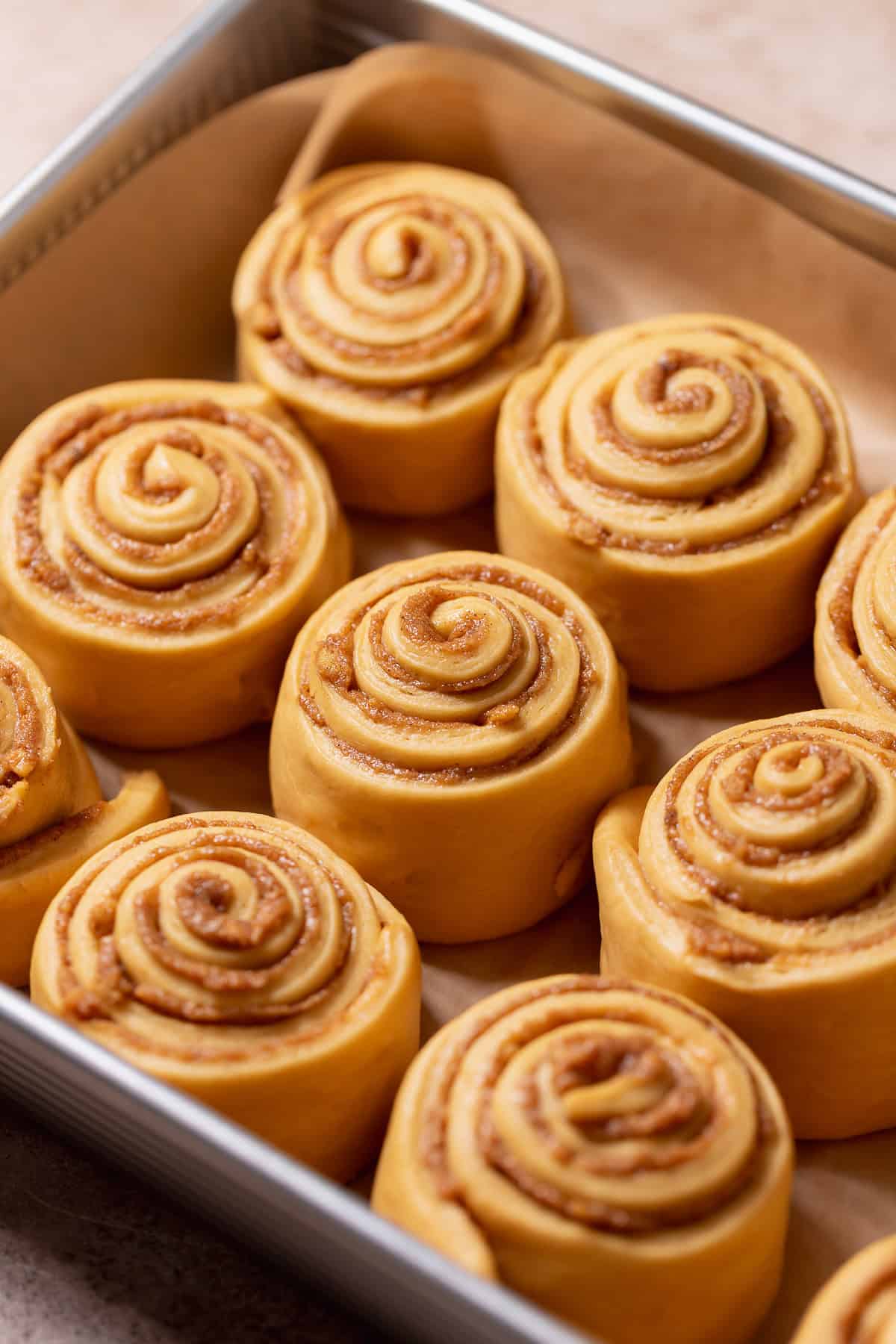 Gingerbread rolls in a baking pan showing they have doubled in size before baking.