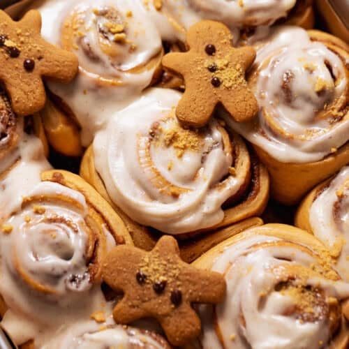 Gingerbread rolls with cream cheese icing in a baking pan.
