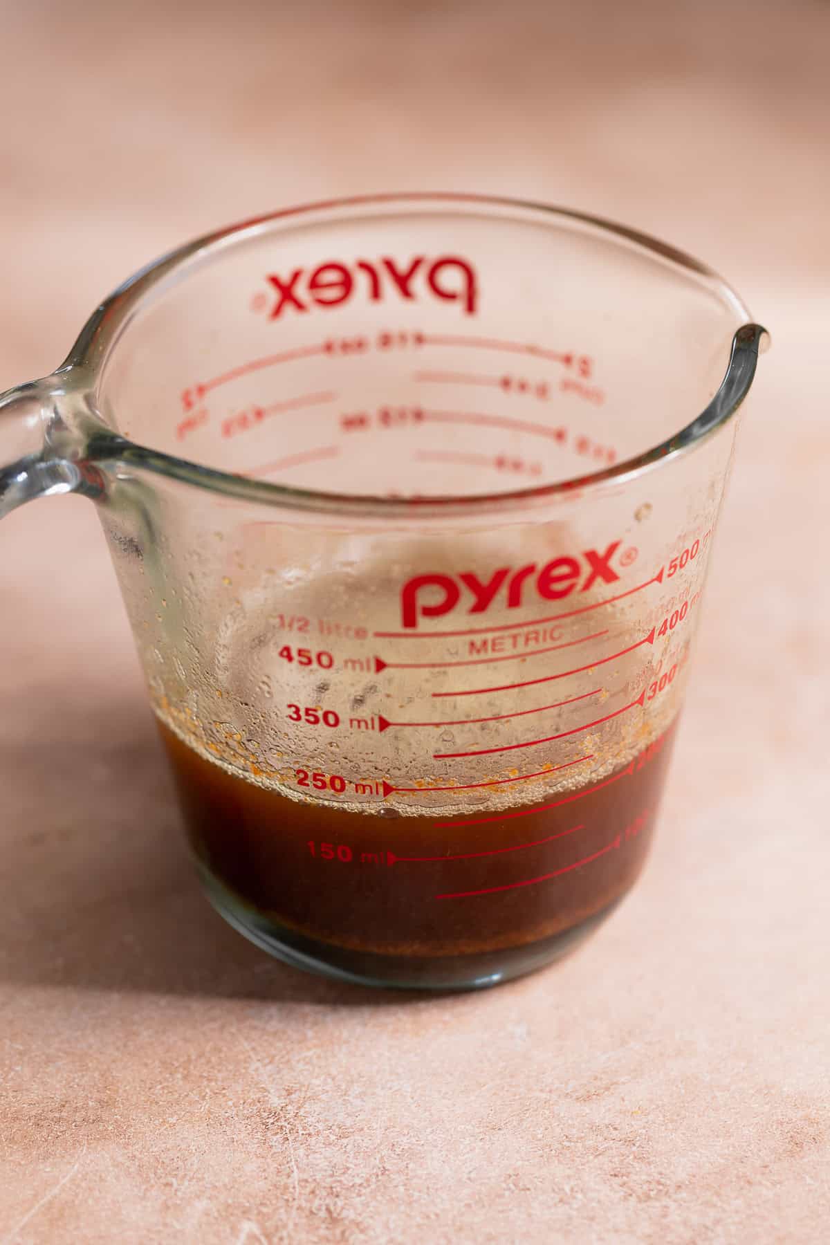 Butter mixture with gingerbread spices in a glass measuring cup.