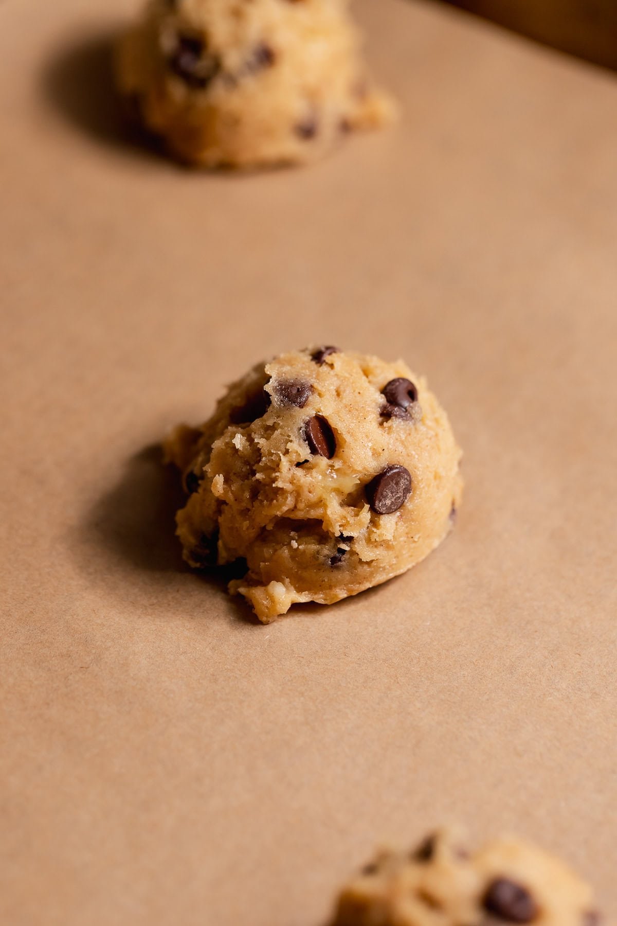 Cookie dough balls on parchment paper right before baking.