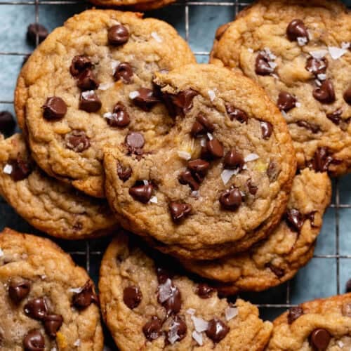 A pile of banana bread cookie studded with chocolate chips and sprinkled with sea salt.
