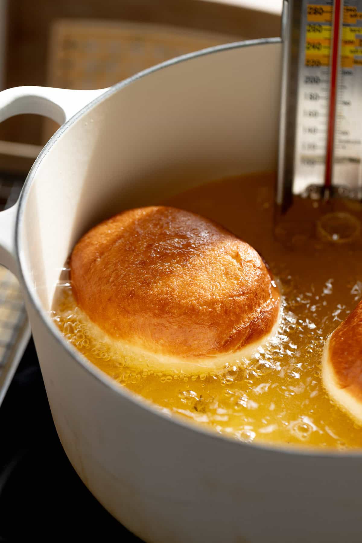 Jelly donut frying in hot oil until golden brown