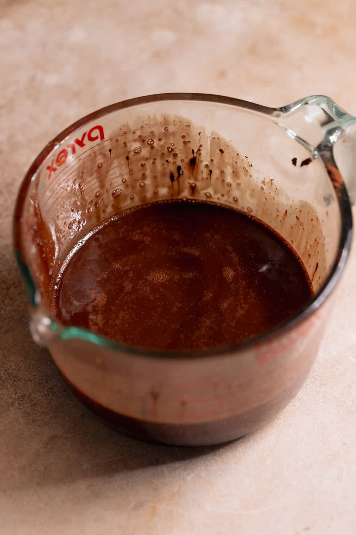Melted chocolate and brown butter mixture in a glass measuring cup.