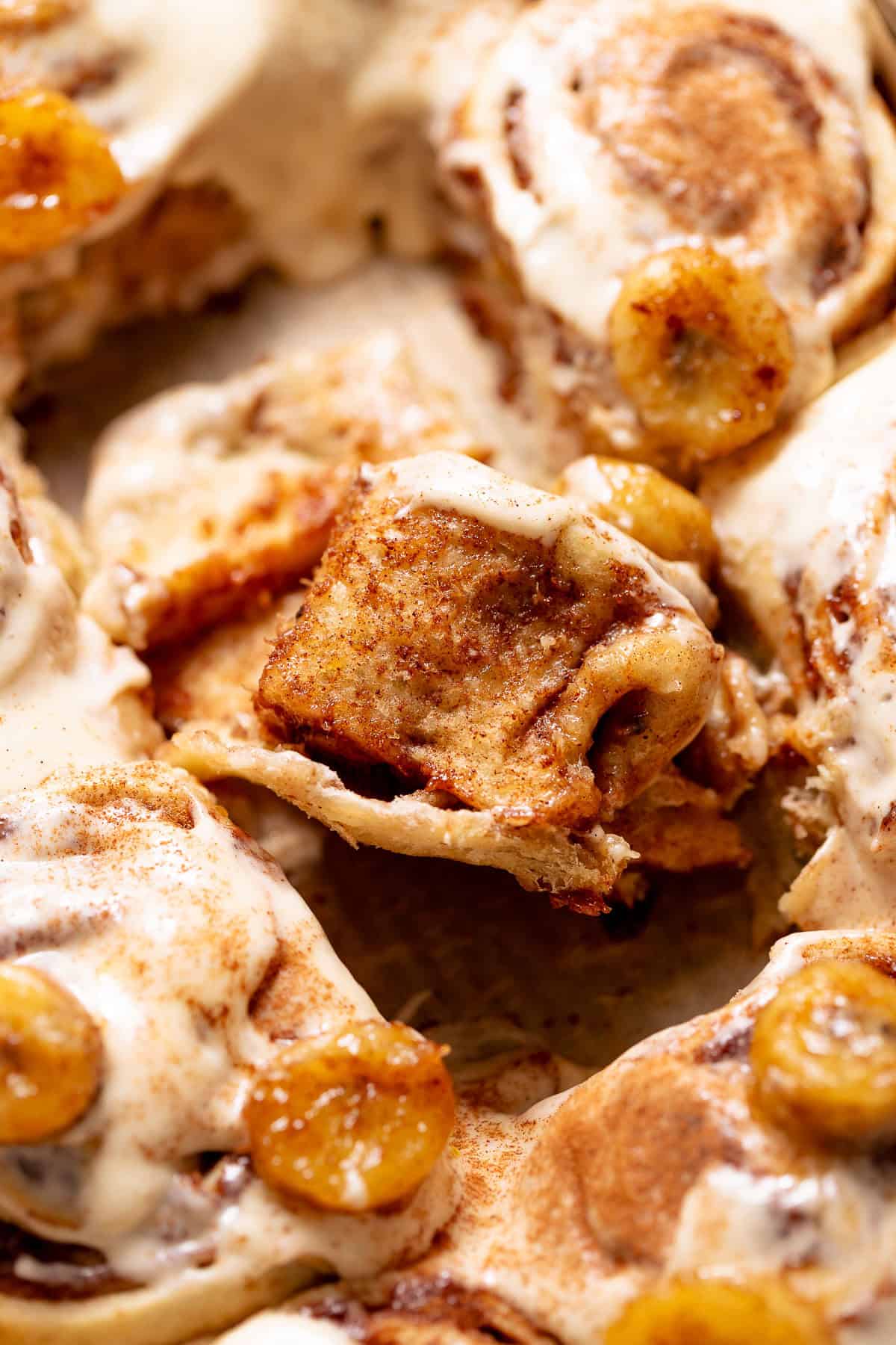 Close-up bite shot of a banana cinnamon roll showing soft interior crumb.