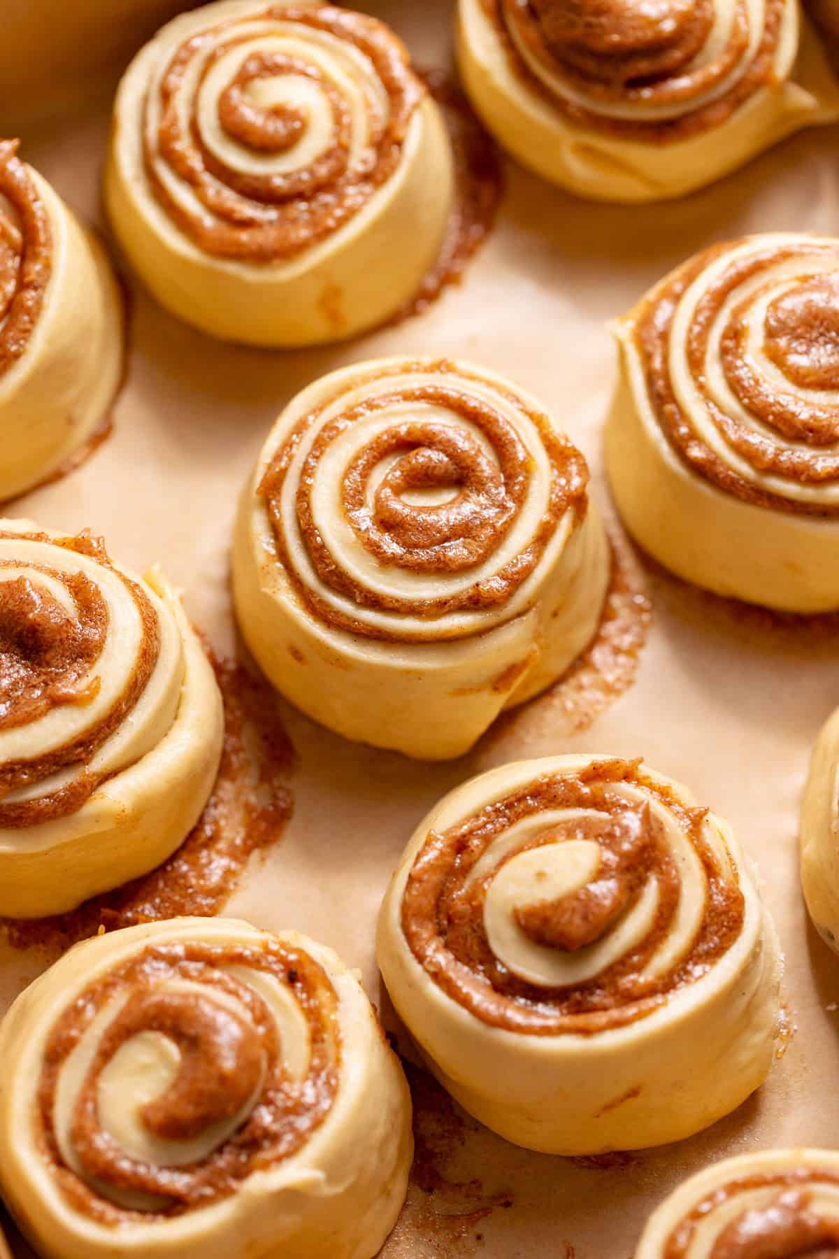 Unbaked cinnamon rolls arranged in a baking pan before proofing.
