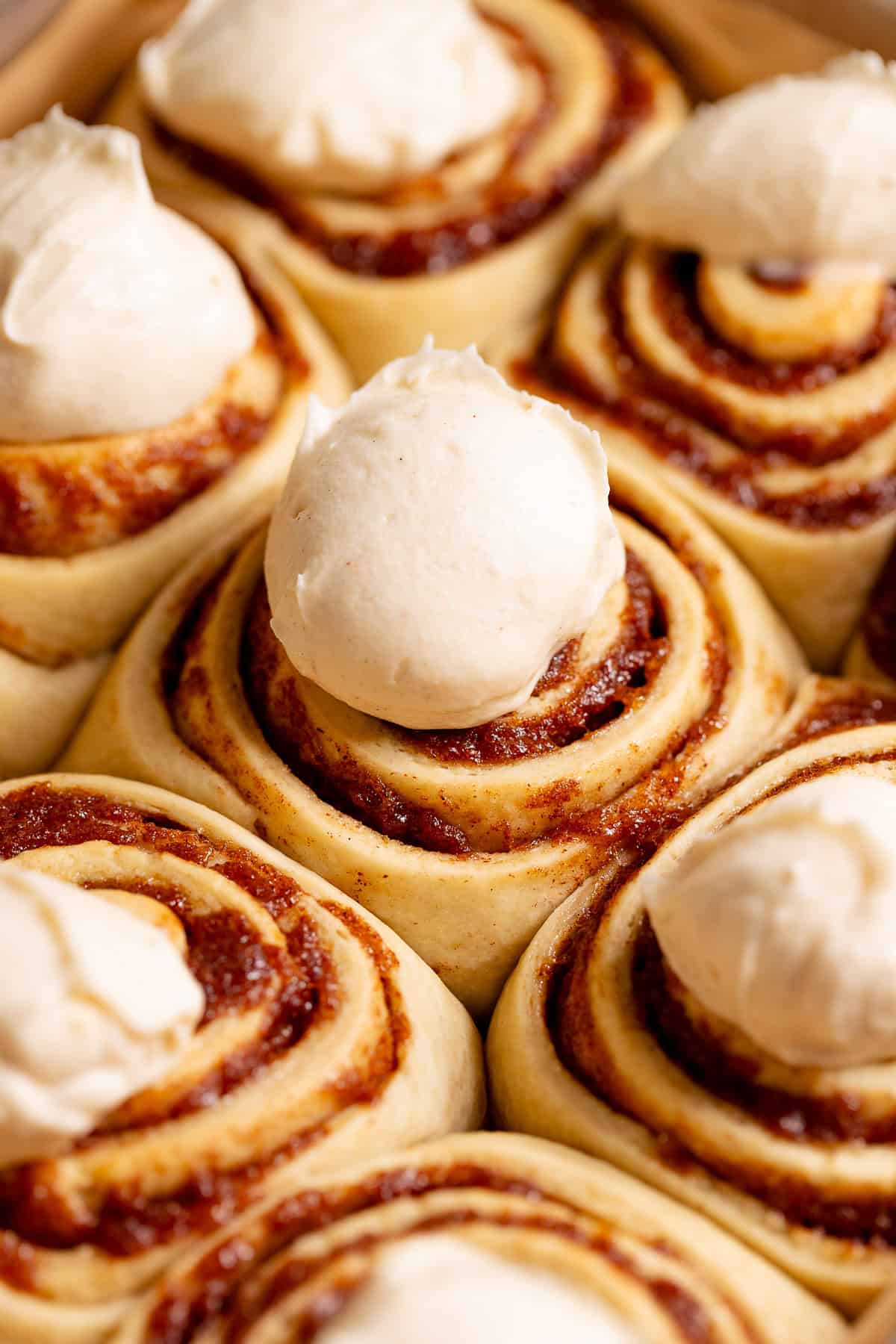 Banana bread rolls generously frosted with cream cheese icing.