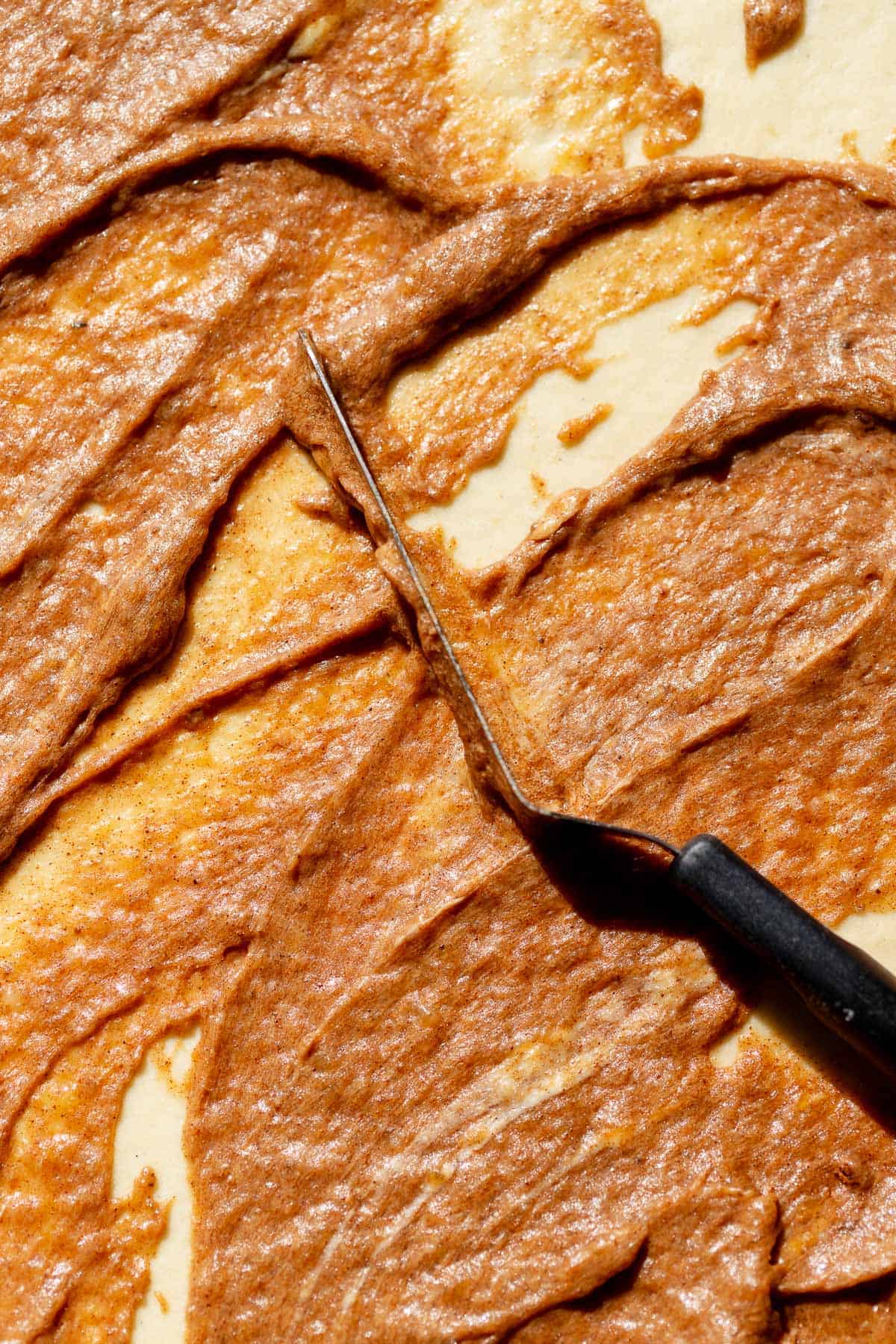 Banana bread cinnamon filling spread evenly over rolled dough.