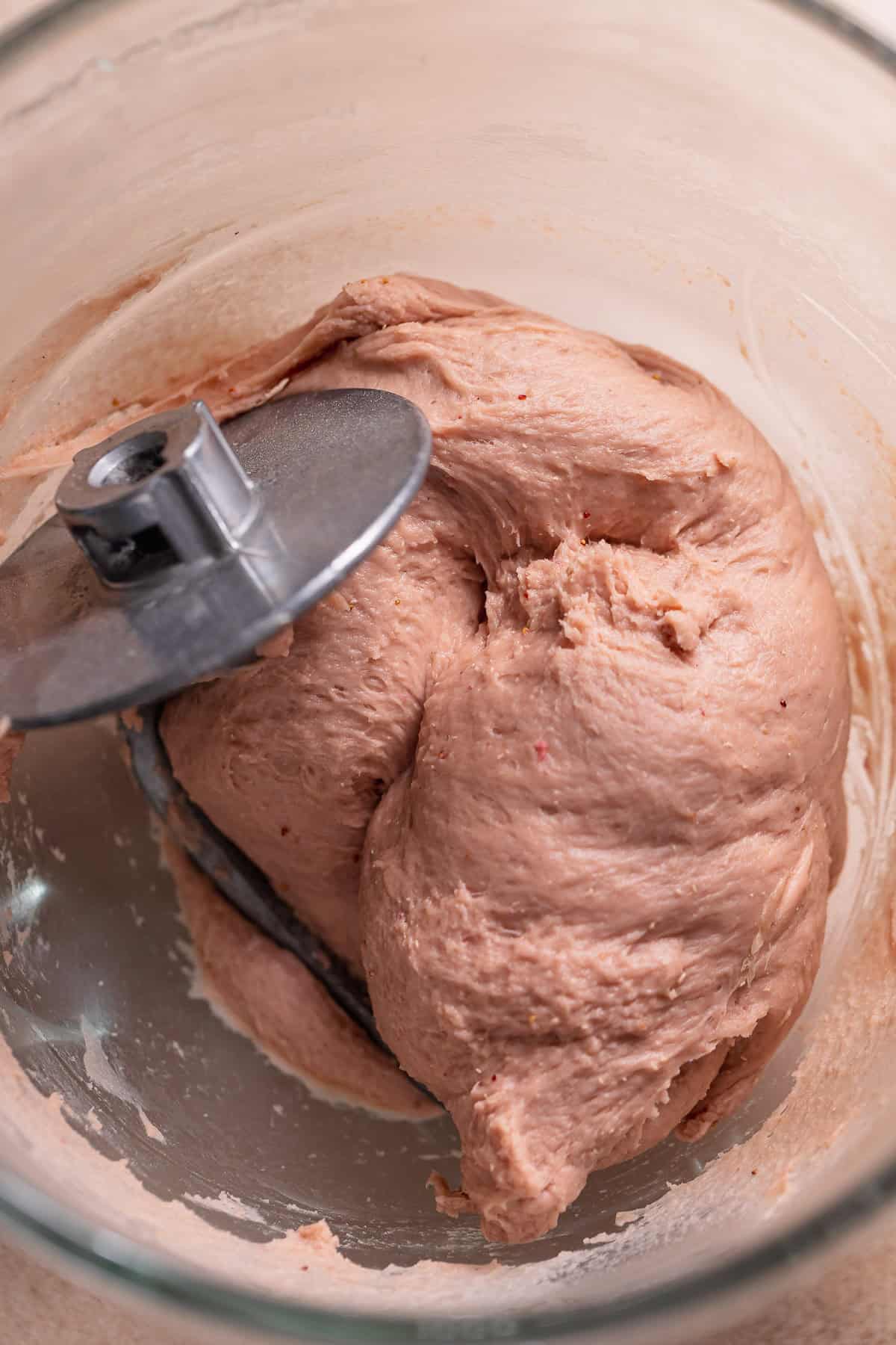 Soft pink dough resting in a mixing bowl.