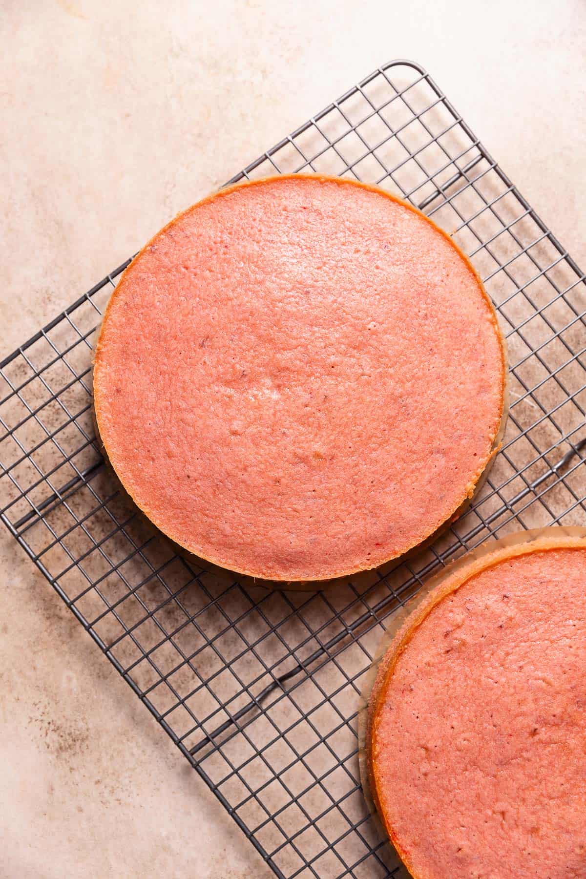 Baked cake layers cooling on a wire rack.