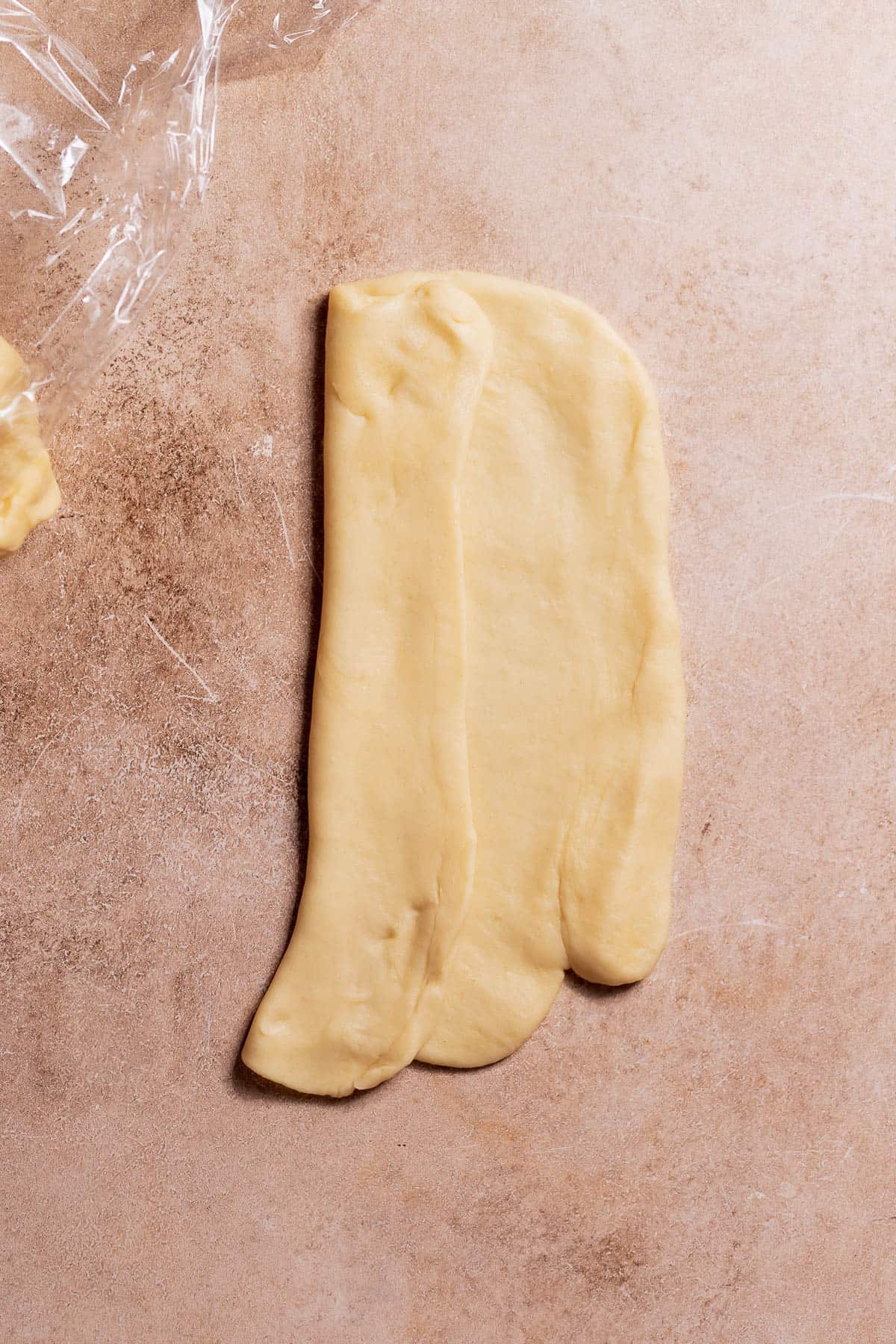 An overhead shot of the rolled out dough being folded in towards to center.