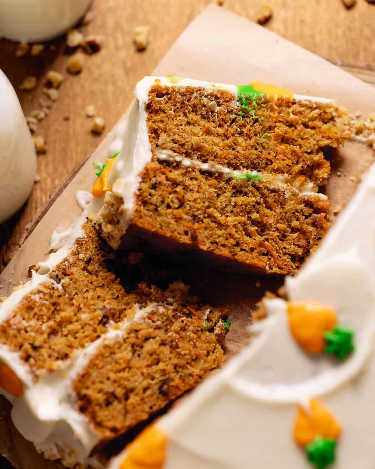 Slices of homemade carrot cake with cream cheese frosting and walnuts.