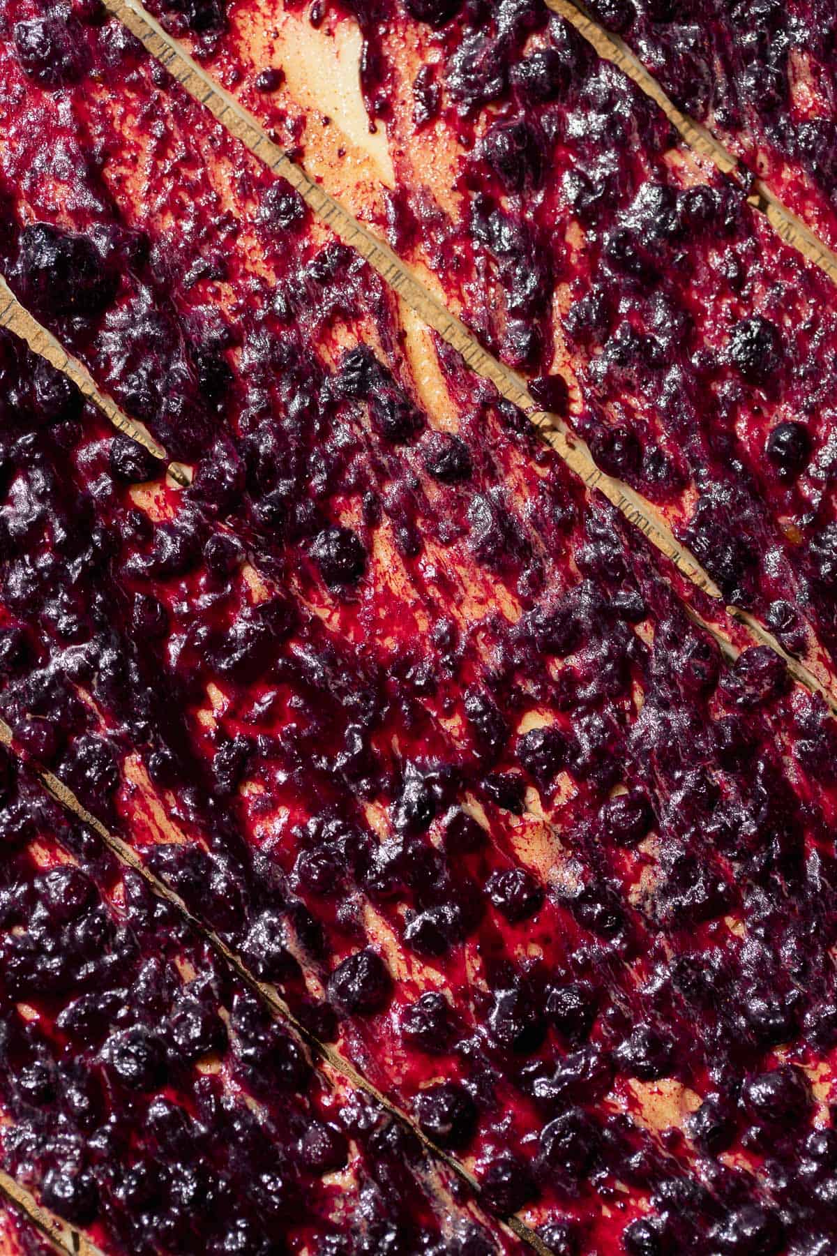 Wild blueberry and brown sugar cinnamon filling spread across rolled-out cinnamon roll dough.