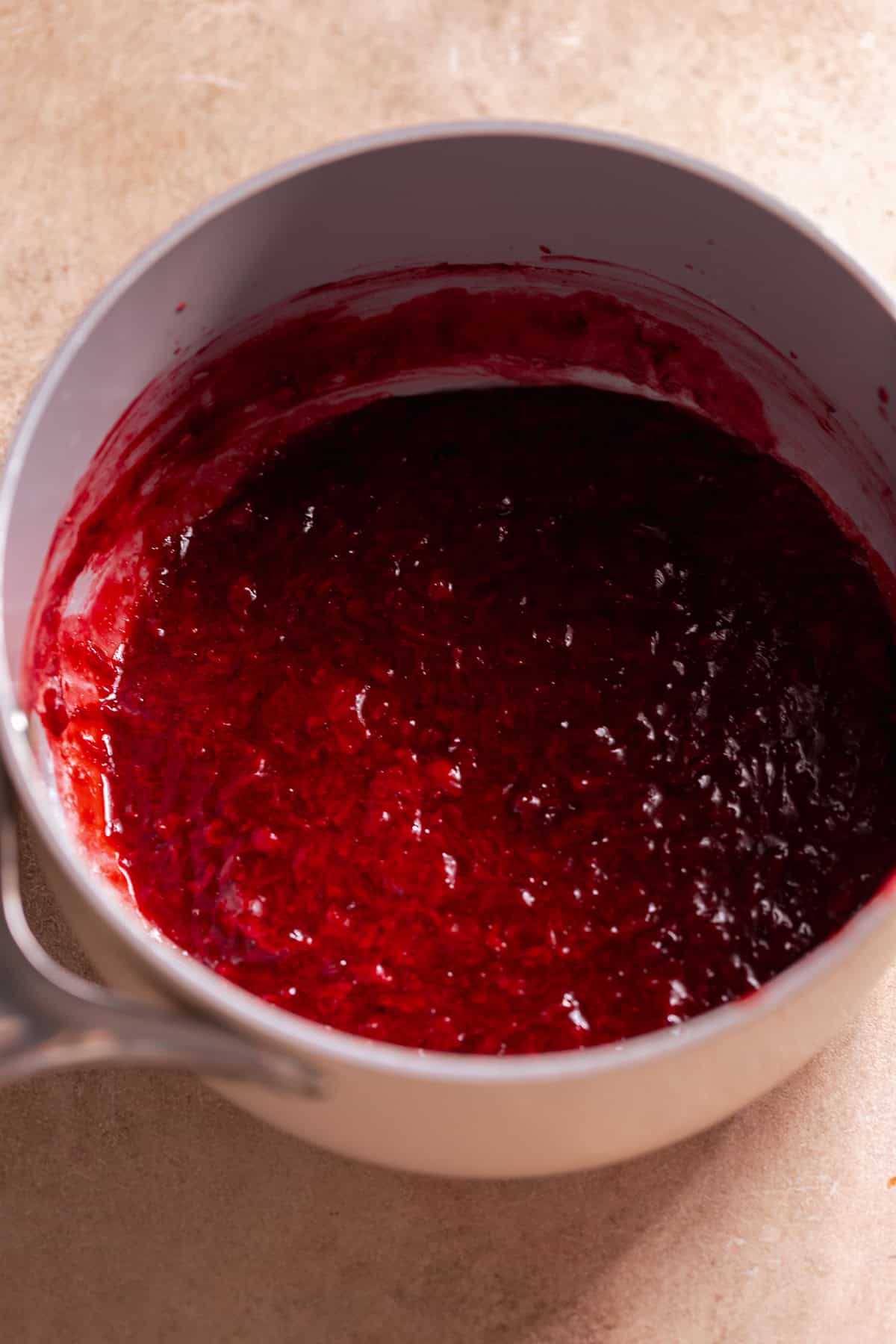 Homemade strawberry jam cooking in a saucepan.