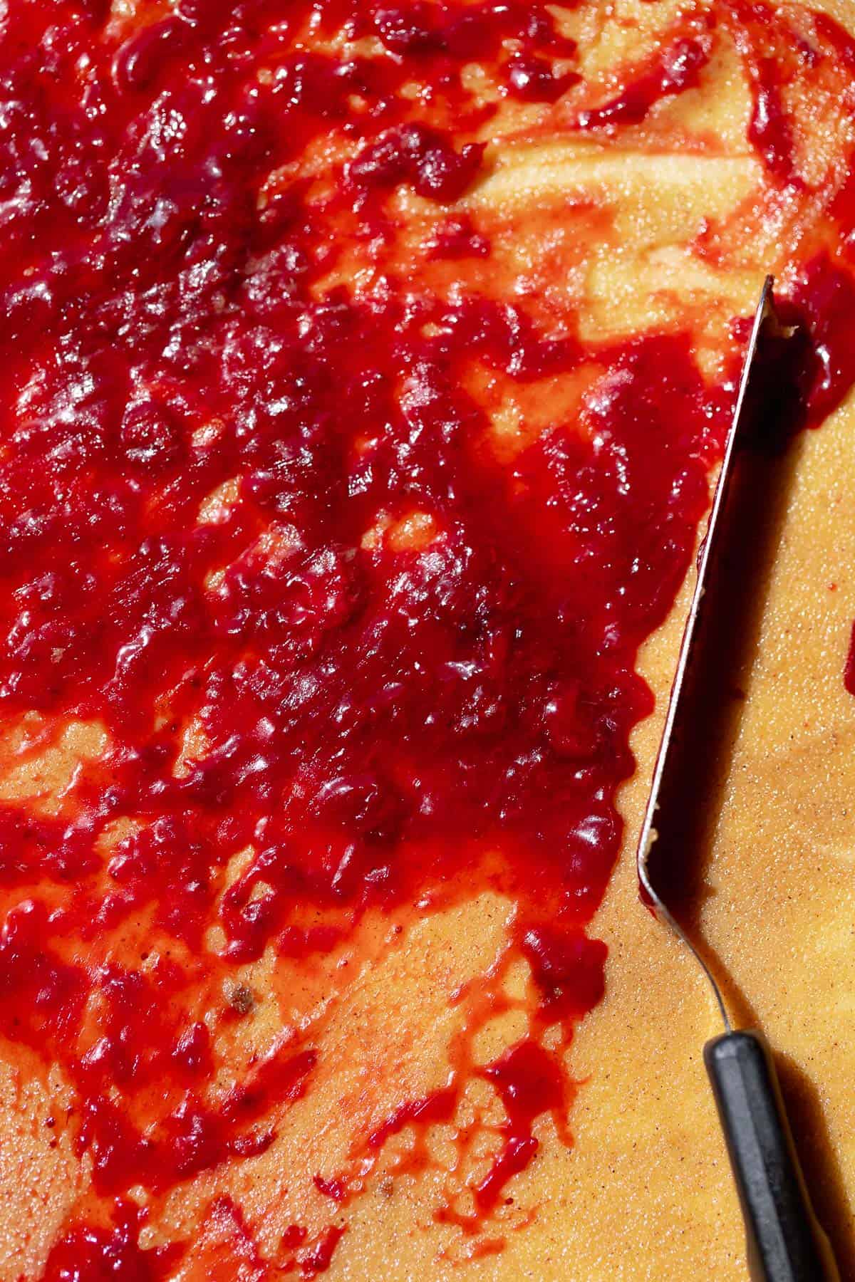 Cinnamon roll dough spread with strawberry jam and brown sugar cinnamon filling.