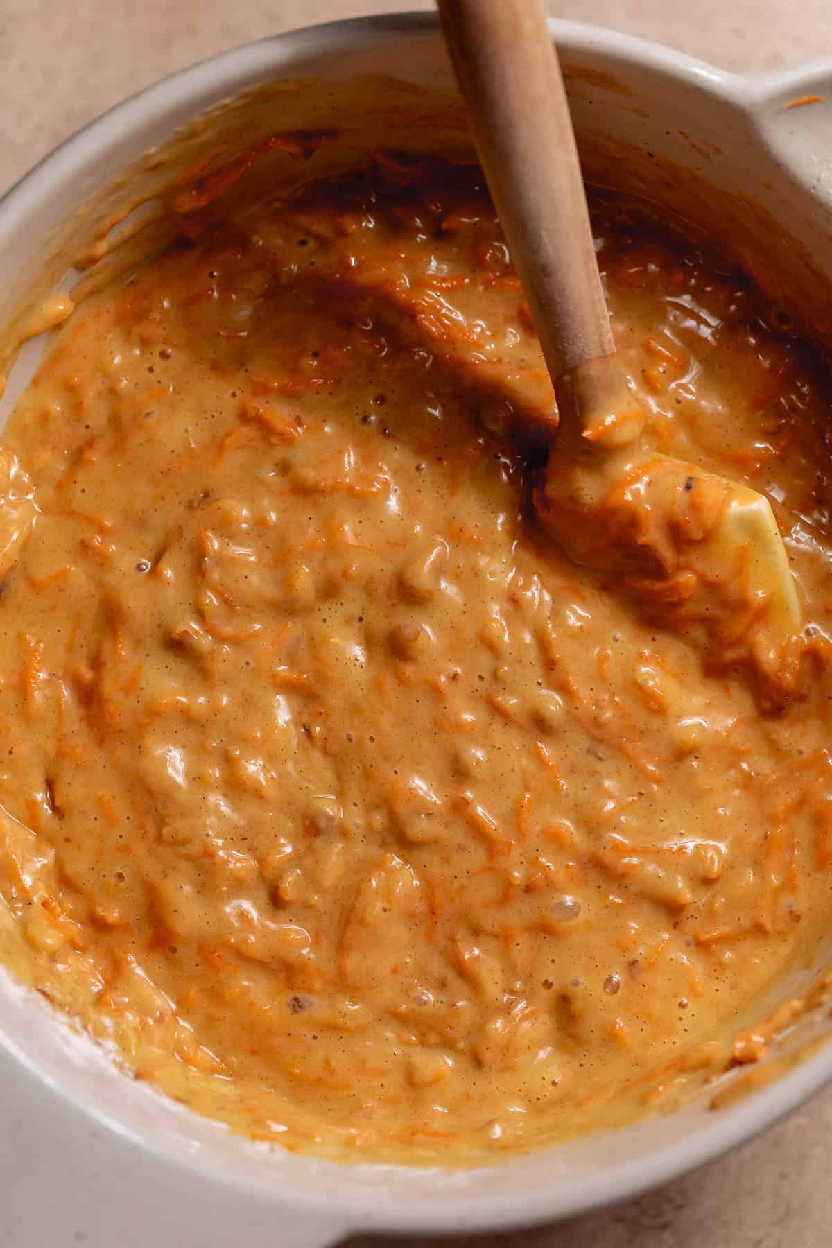 Thick carrot cake batter with grated carrots and chopped walnuts.