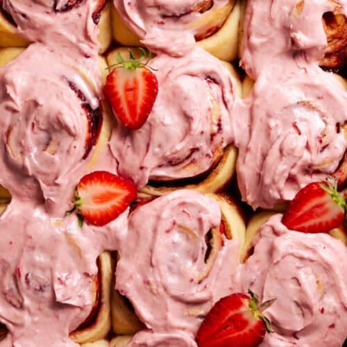Overhead view of strawberry sweet rolls with pink strawberry frosting.