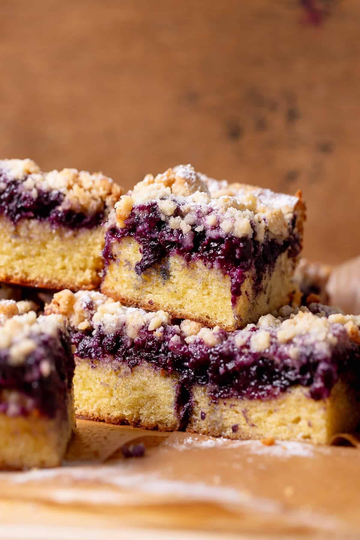 Stacked blueberry crumb cake slices with a thick blueberry layer and buttery crumb topping.