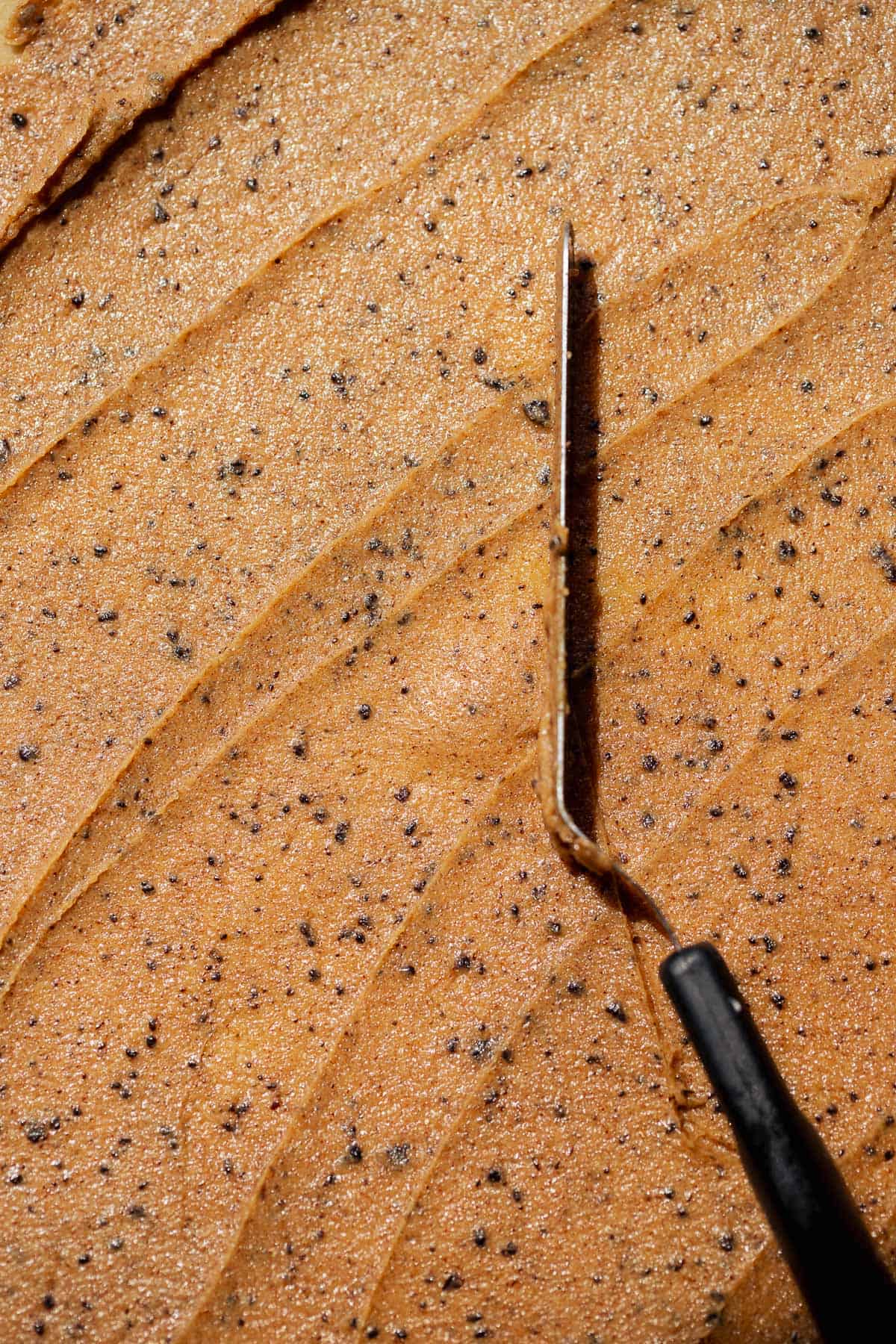 Coffee cinnamon sugar filling spread evenly over rolled dough with visible espresso granules and butter.