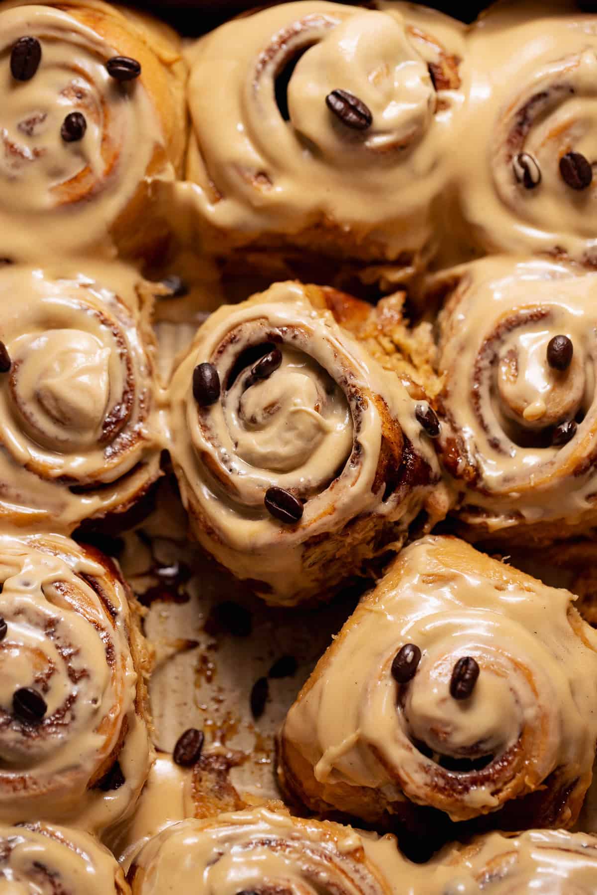 Gooey coffee-flavored cinnamon rolls with melted espresso frosting pooling between the swirls.