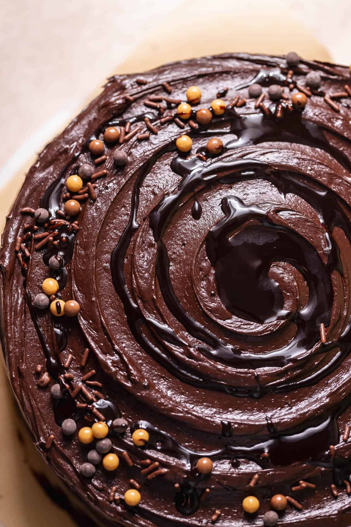 Top view of a chocolate cake with swirled chocolate frosting and chocolate sprinkles