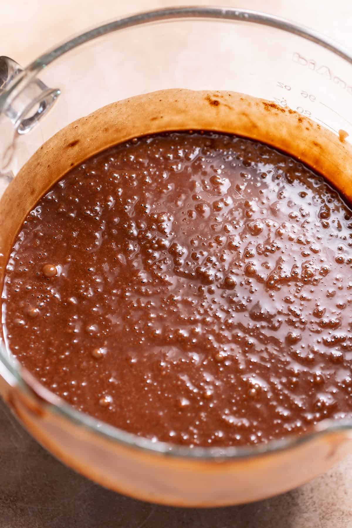 Smooth chocolate cake batter in a mixing bowl with a glossy, thick consistency.