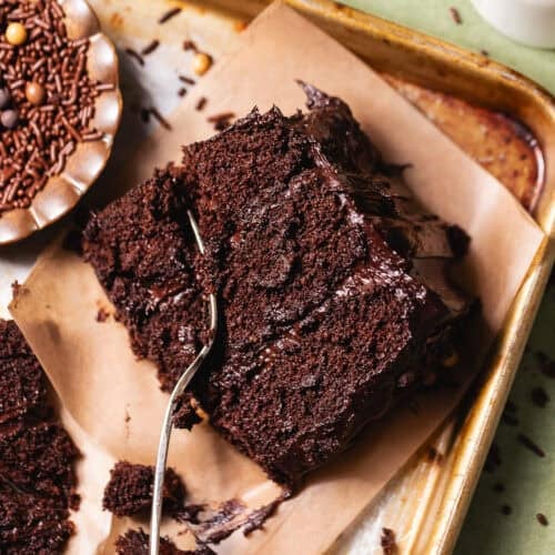 Close-up of a slice of moist chocolate cake with soft crumb and chocolate frosting.