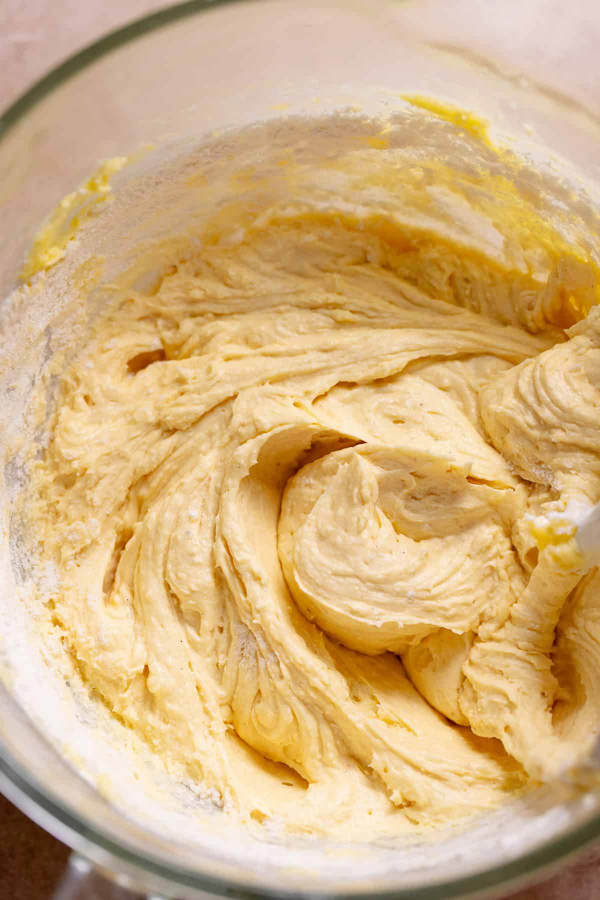 Thick vanilla cake batter in a glass mixing bowl after mixing.
